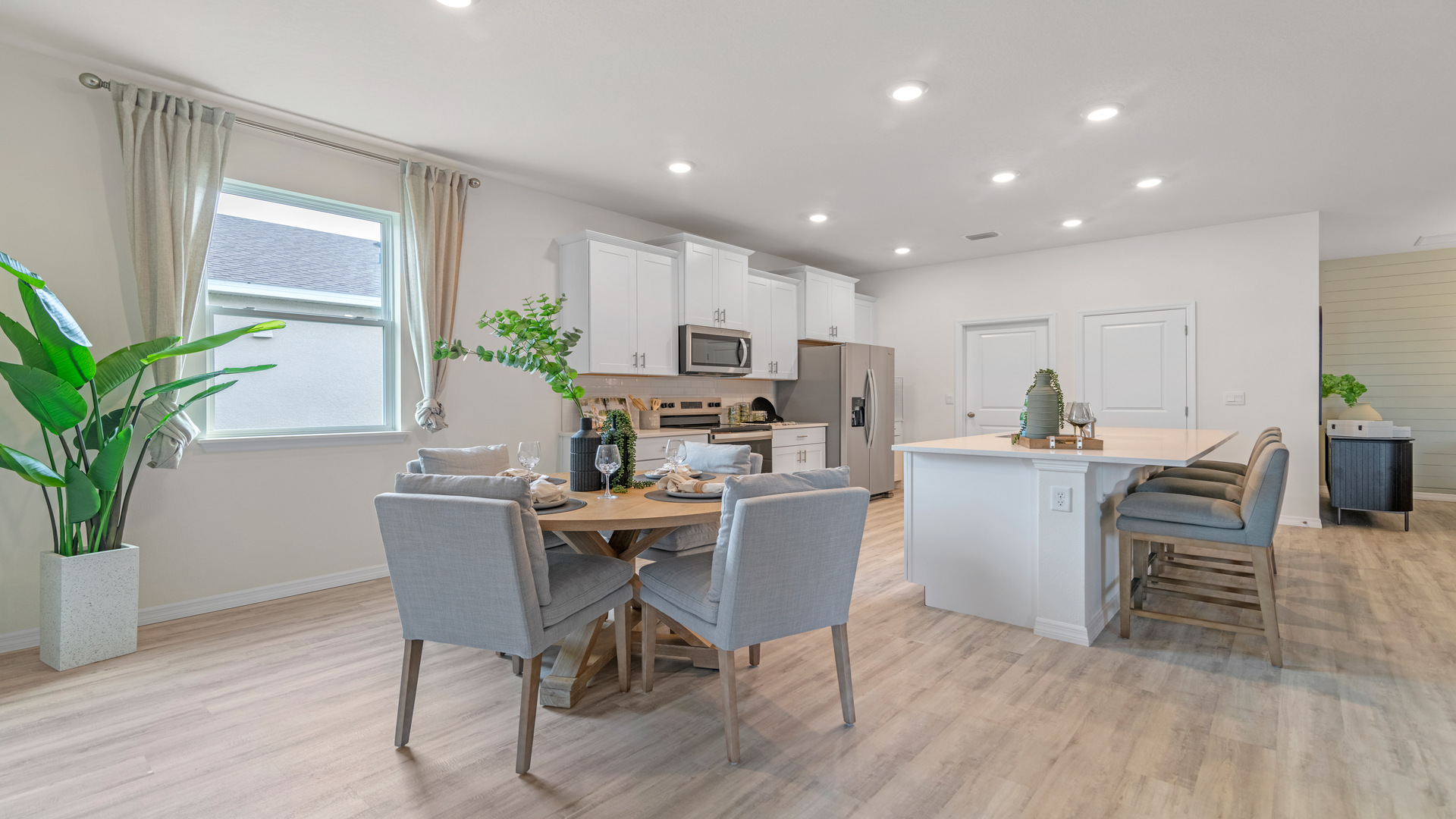 Kitchen with island seating, quartz counters, spacious pantry and stainless-steel appliances and dining room table