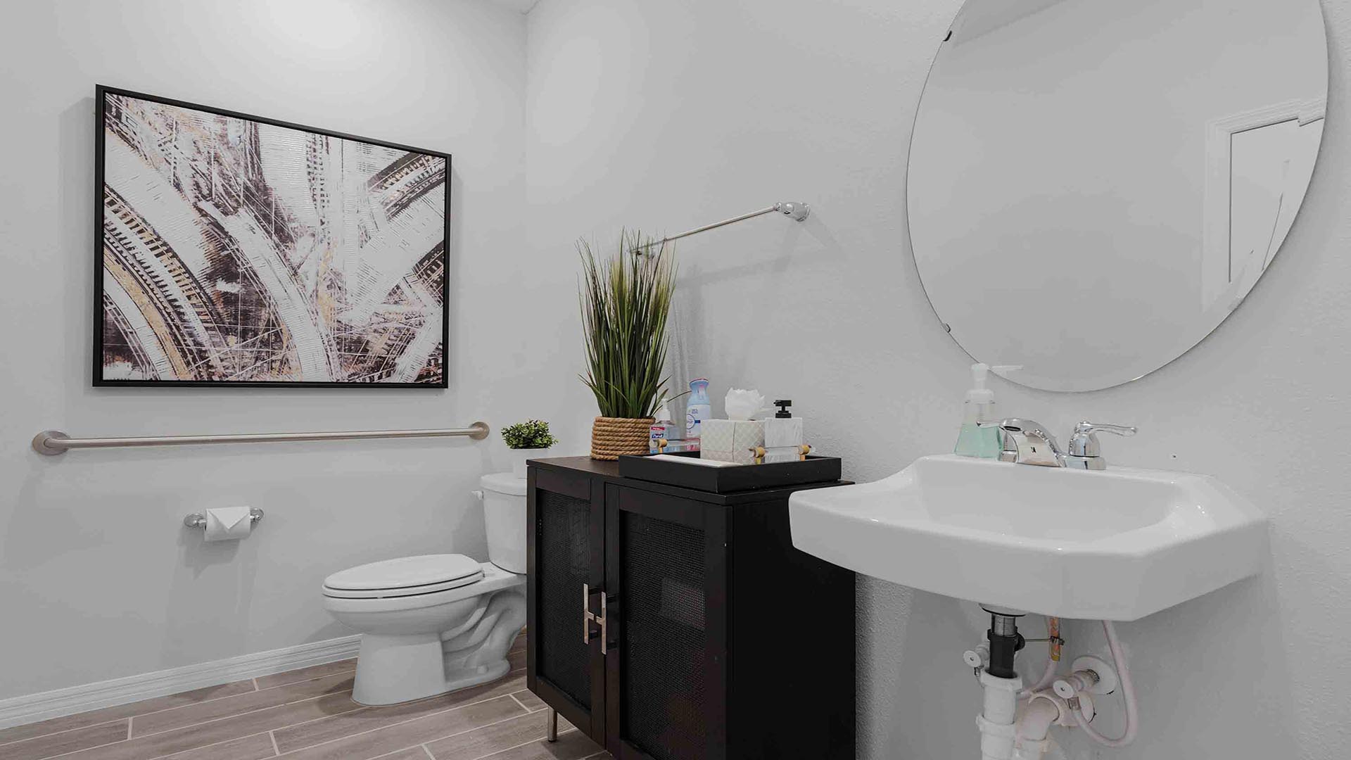 Modern primary bathroom with double vanity countertops with granite, cabinets and large wall mirror.