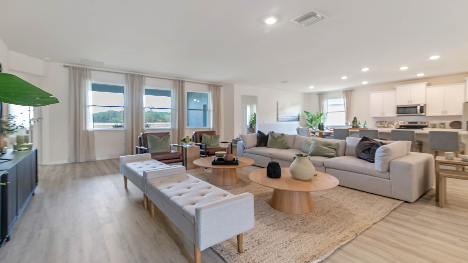 Open concept living area with couch seating and access to the backyard thru slider door.
