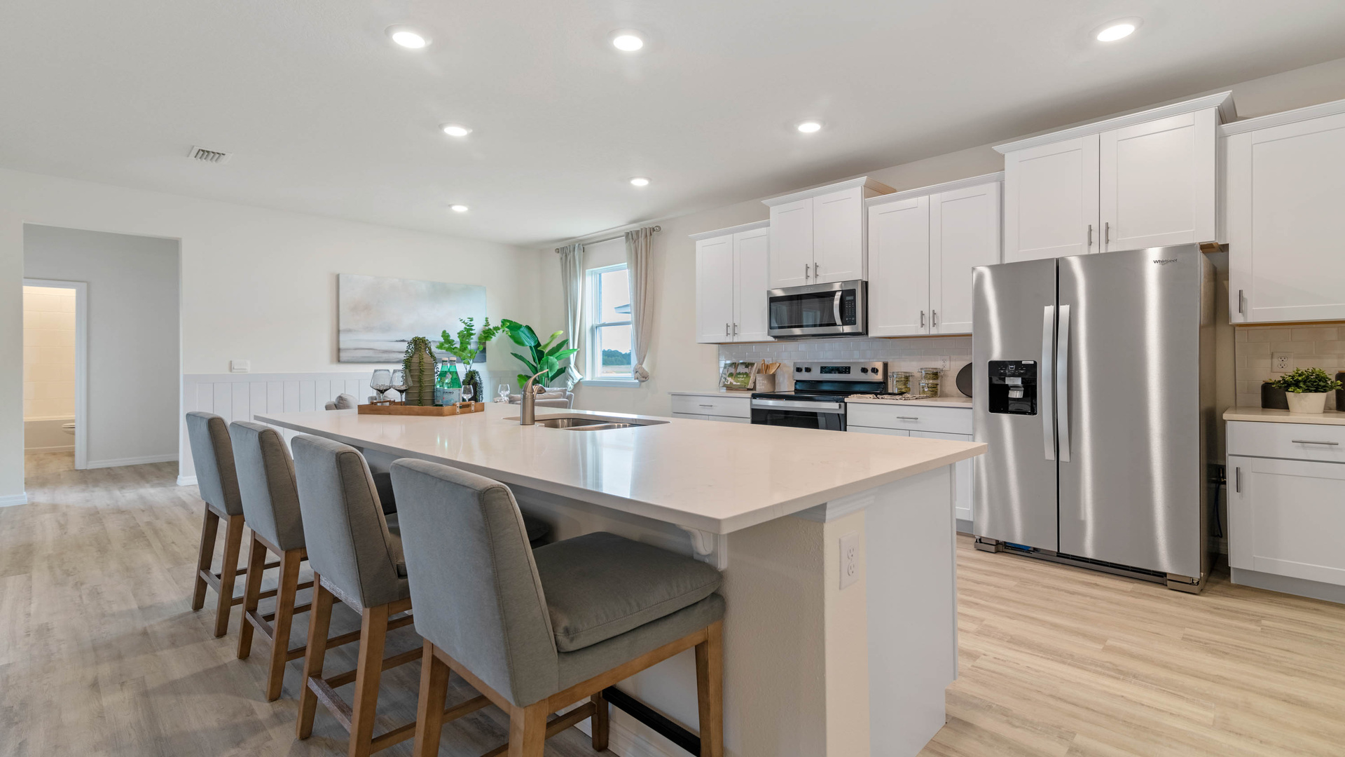 Kitchen with island seating, granite counters, spacious pantry and stainless-steel appliances.