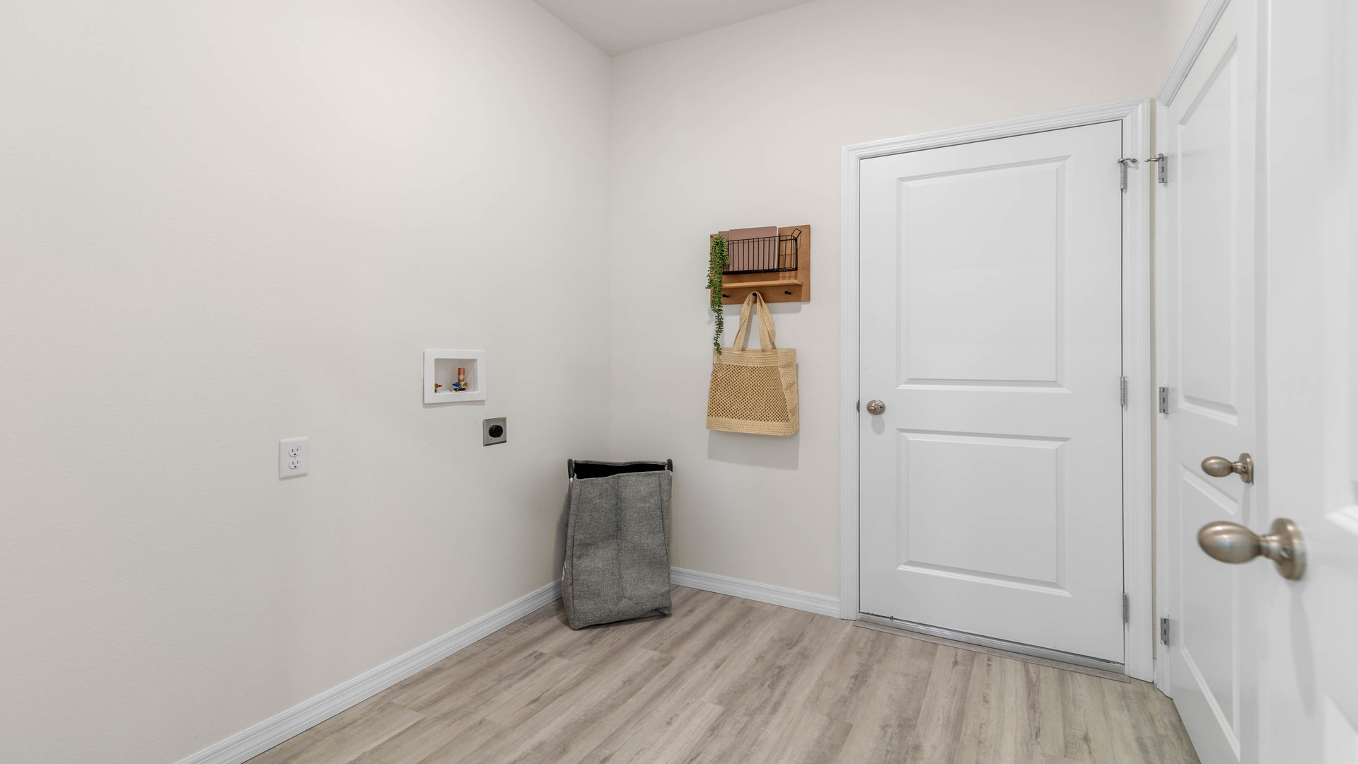 Laundry room with washer and dryer hookups and wall shelving.