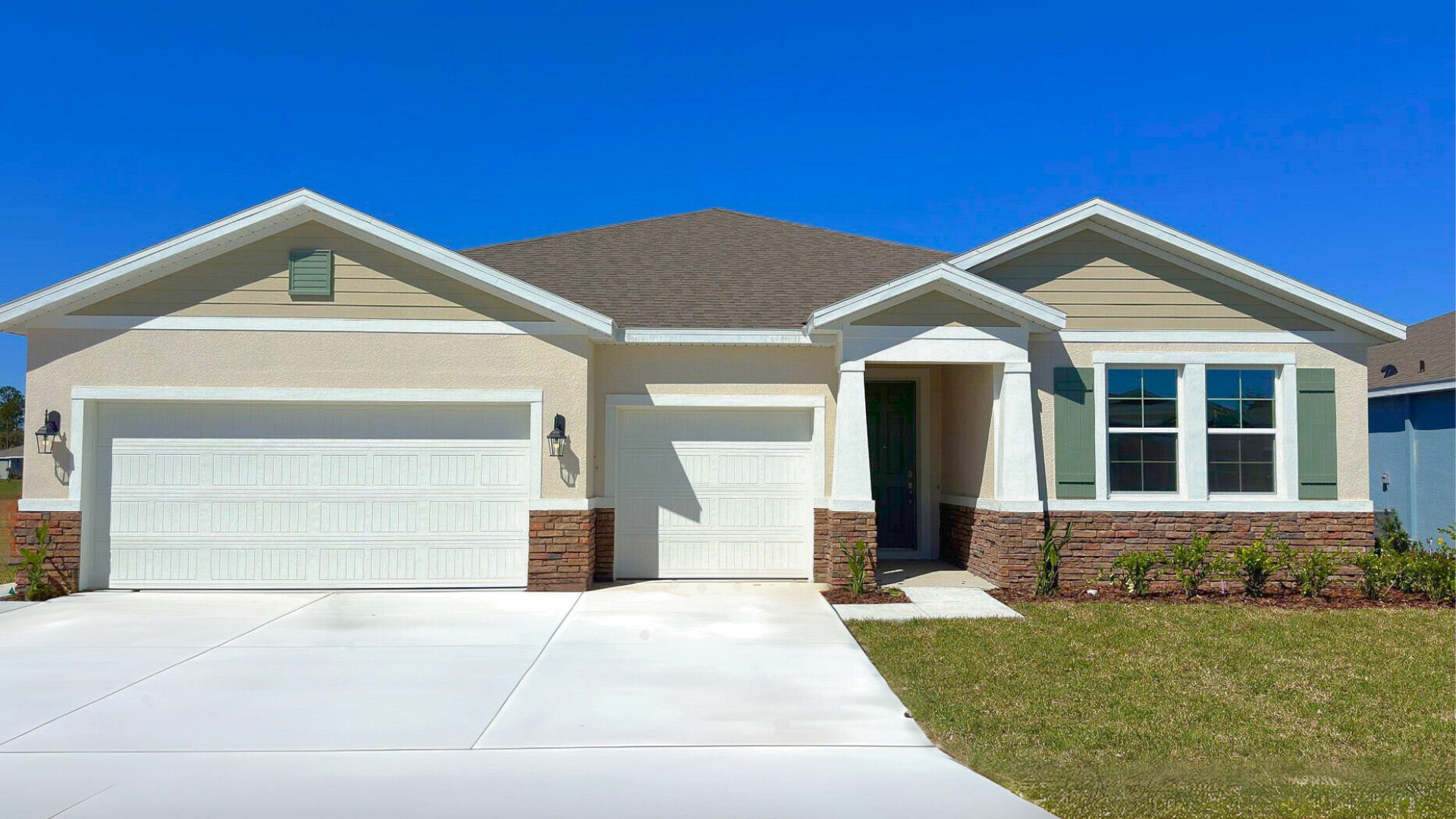 Single story new home with large windows and 2 car garage.
