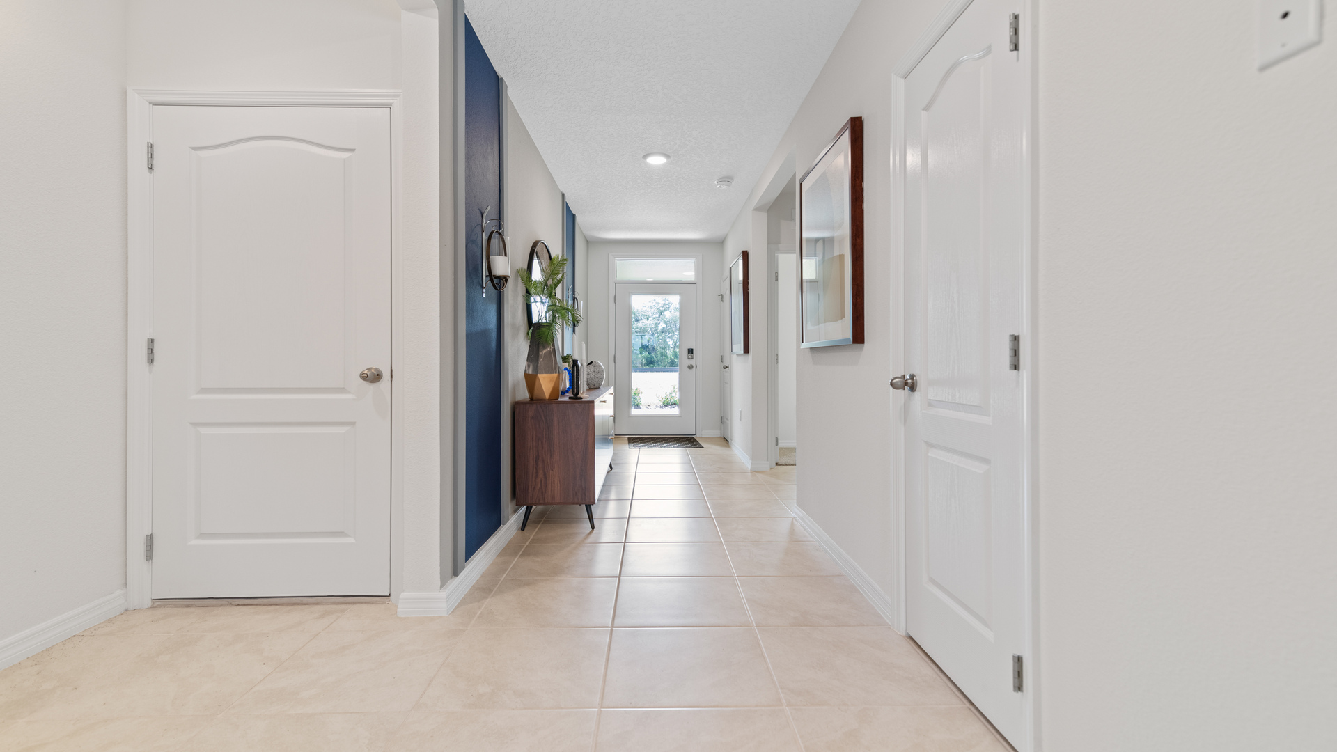 Home entry way thru the front door with tile flooring and a view to the living space.