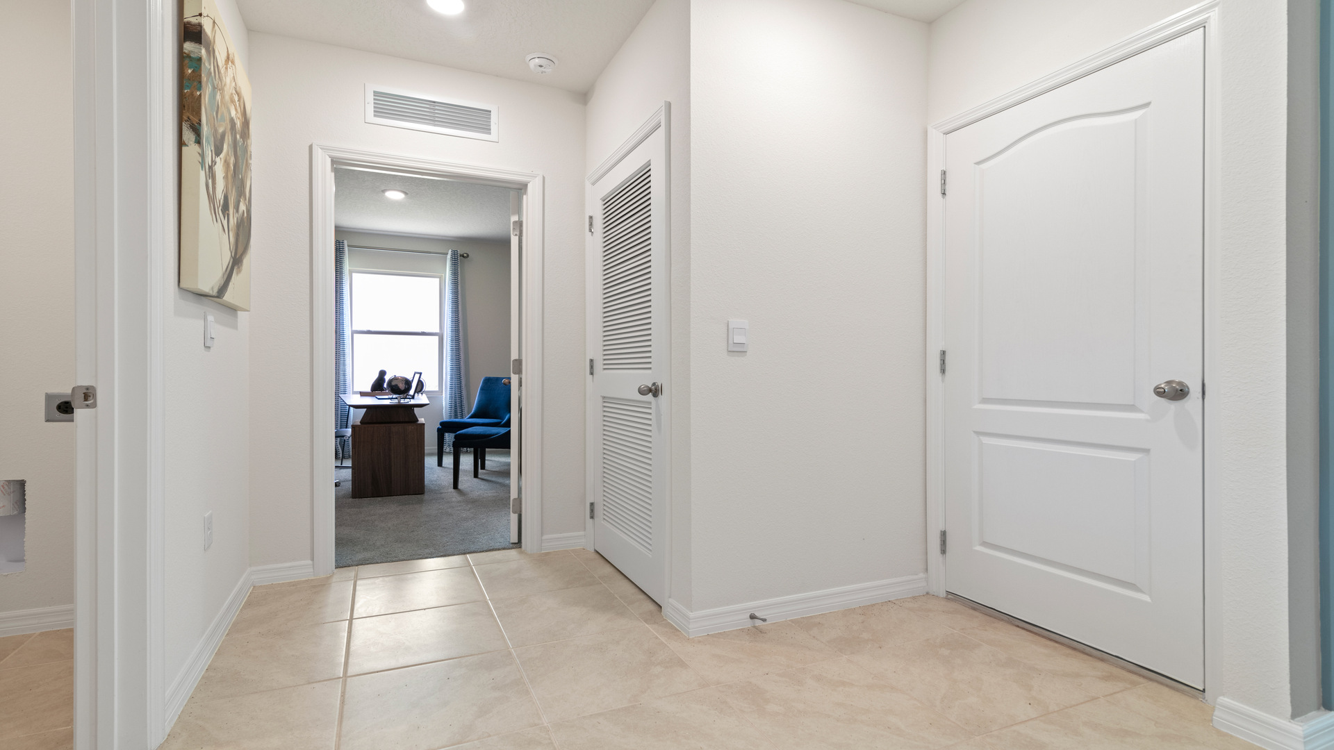 Home entry way thru the front door with tile flooring and a view to the living space.