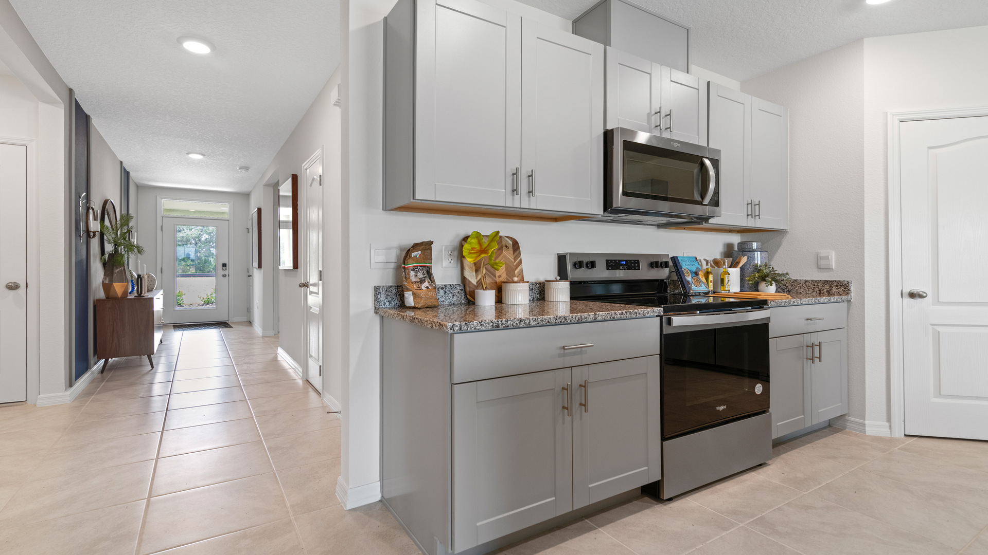 Kitchen with island seating, granite counters, spacious pantry and stainless-steel appliances.