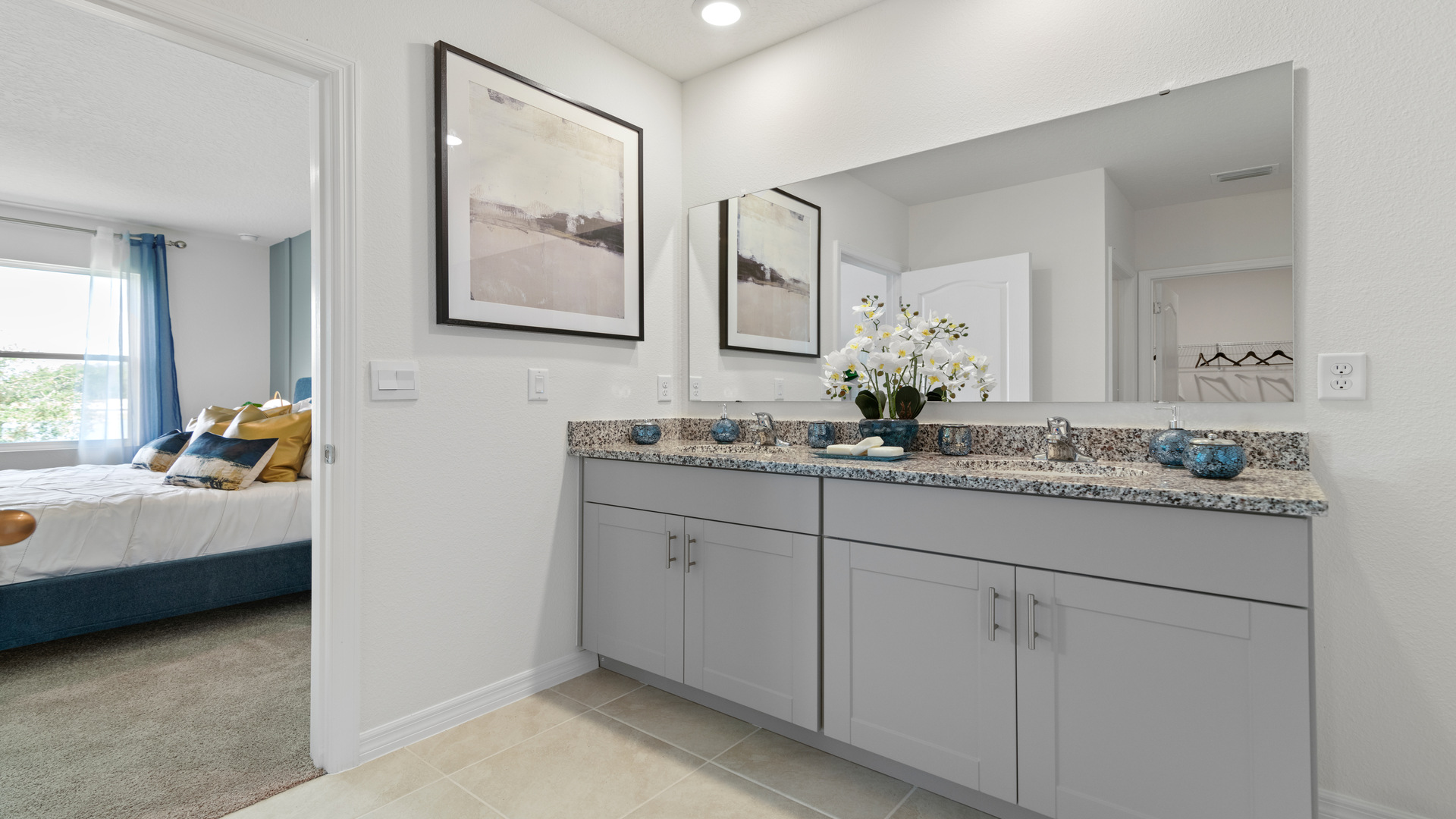 Modern bathroom with double vanity sinks, large wall mirror, cabinets and granite countertops.