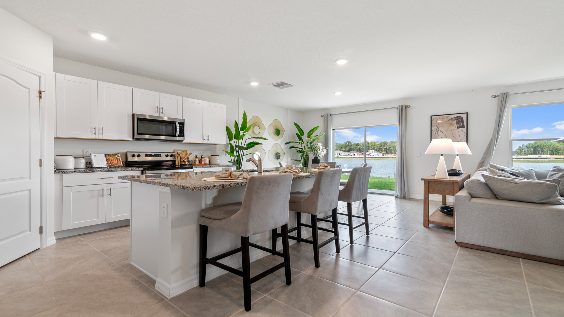 Kitchen with island seating, granite counters, spacious pantry and stainless-steel appliances.