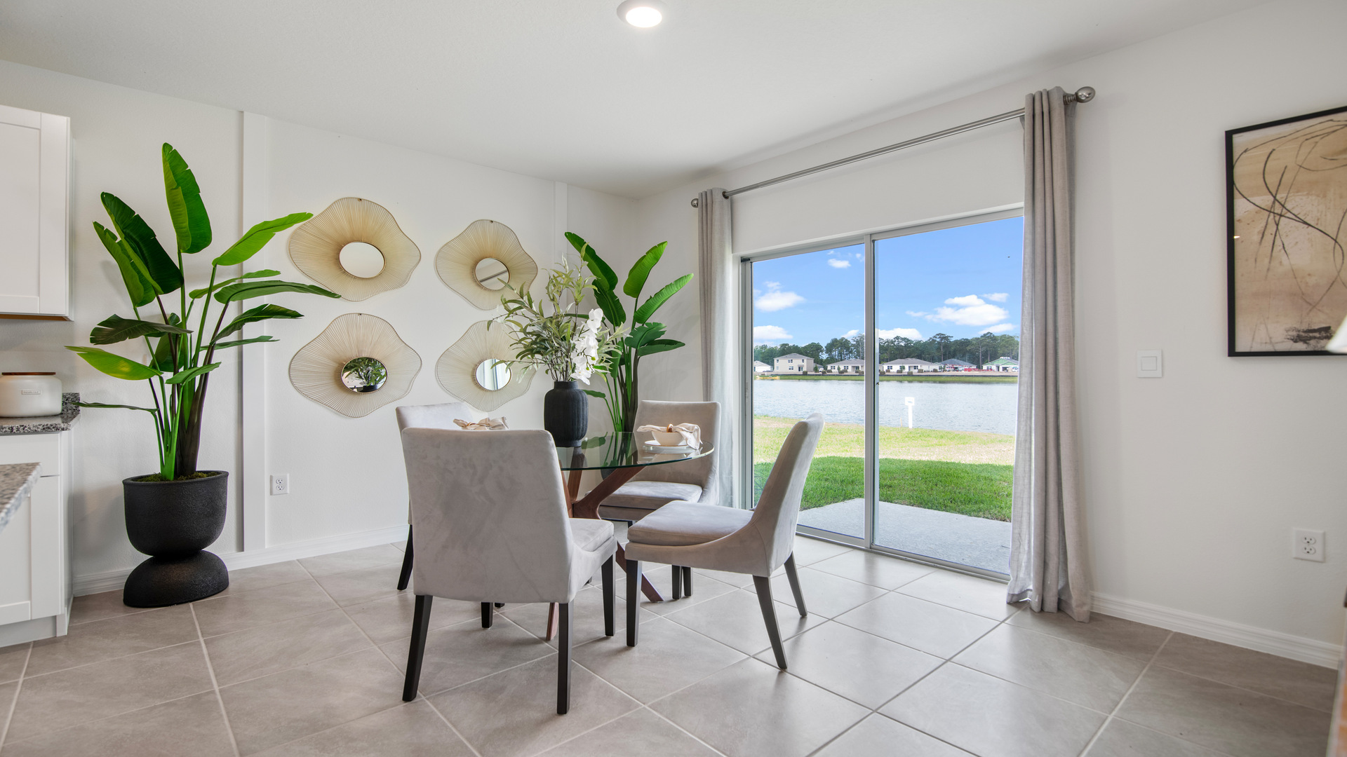 Dining room adjacent to the kitchen with table, chairs and tile flooring.