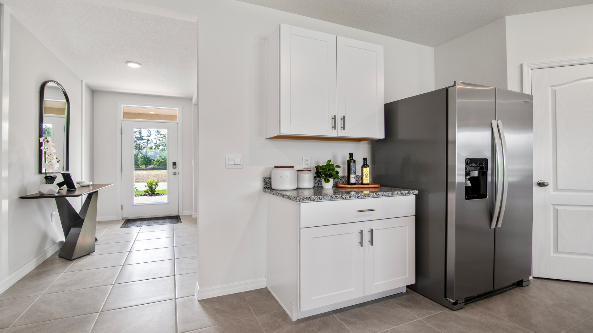 Kitchen with island seating, granite counters, spacious pantry and stainless-steel appliances.