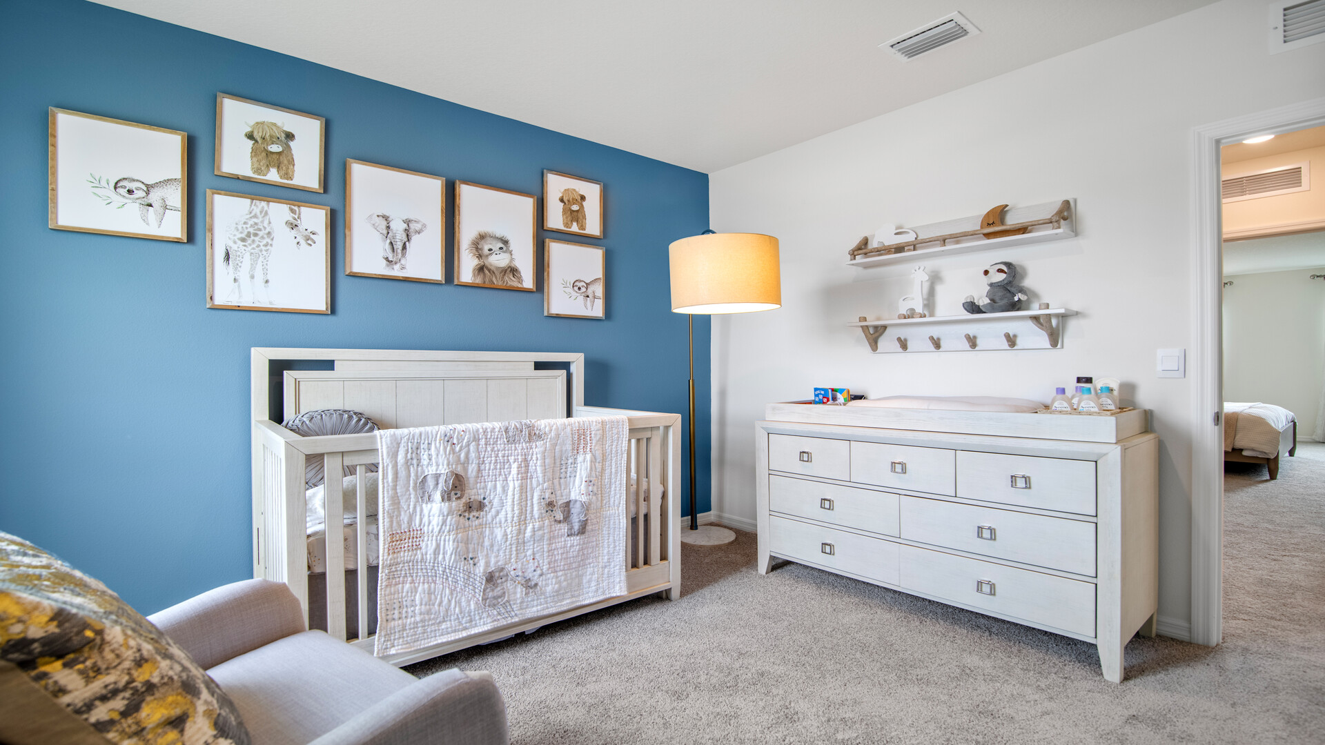 Child's nursery with crib, closet, soft seating and storage.