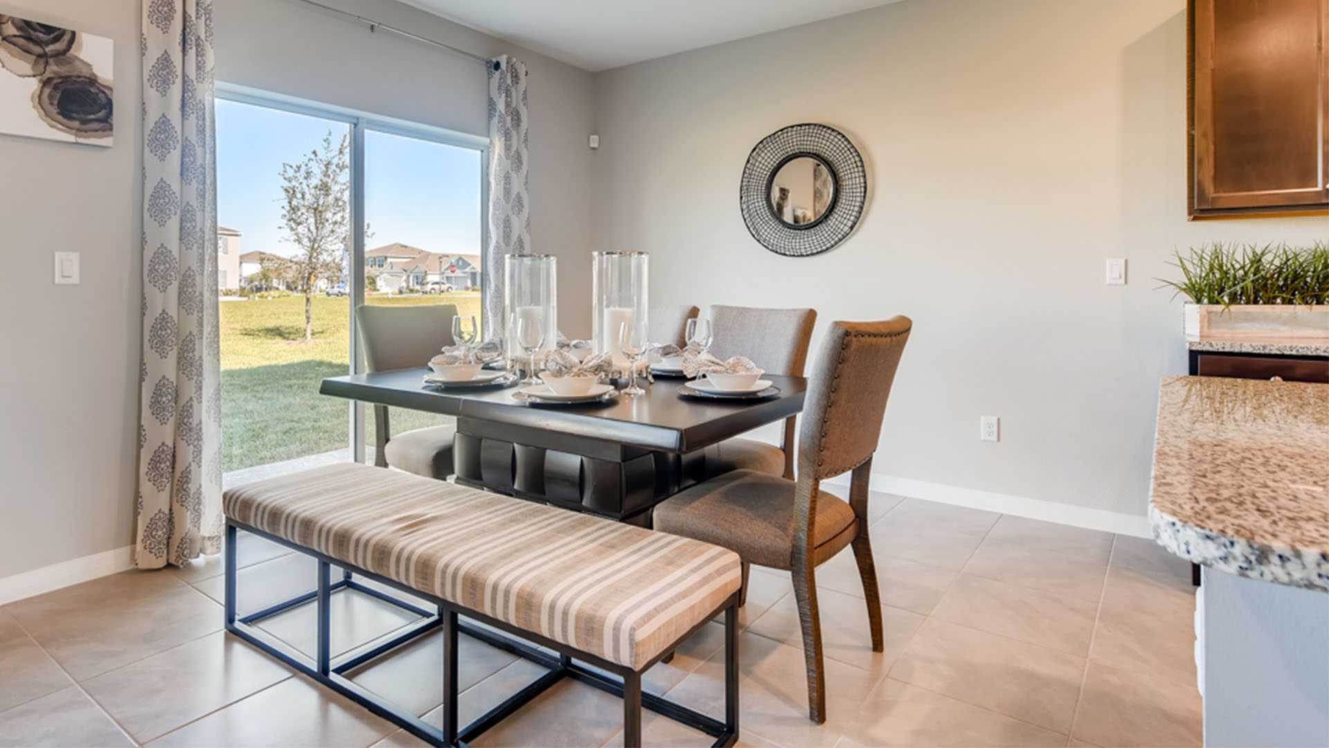 Dining room adjacent to the kitchen with table, chairs and tile flooring.