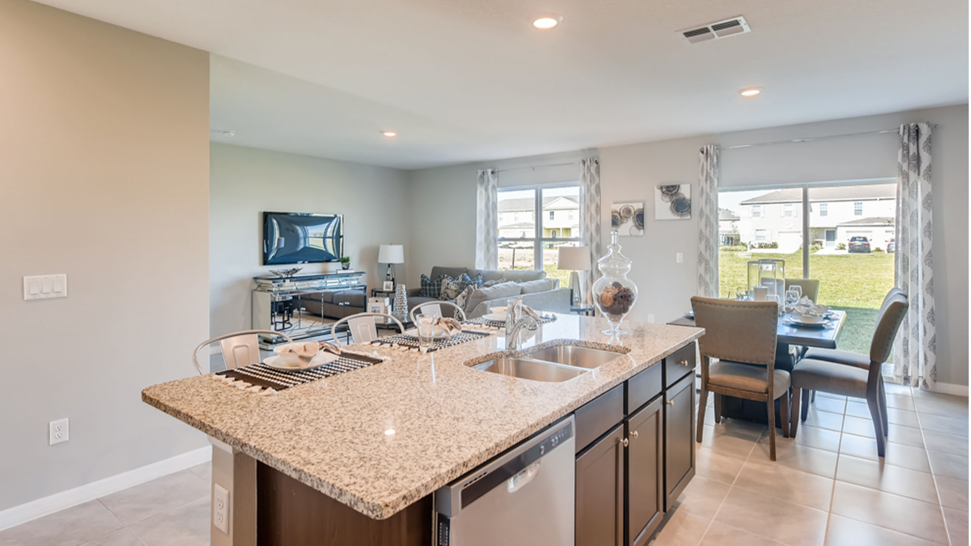 Kitchen with island seating, granite counters, spacious pantry and stainless-steel appliances.