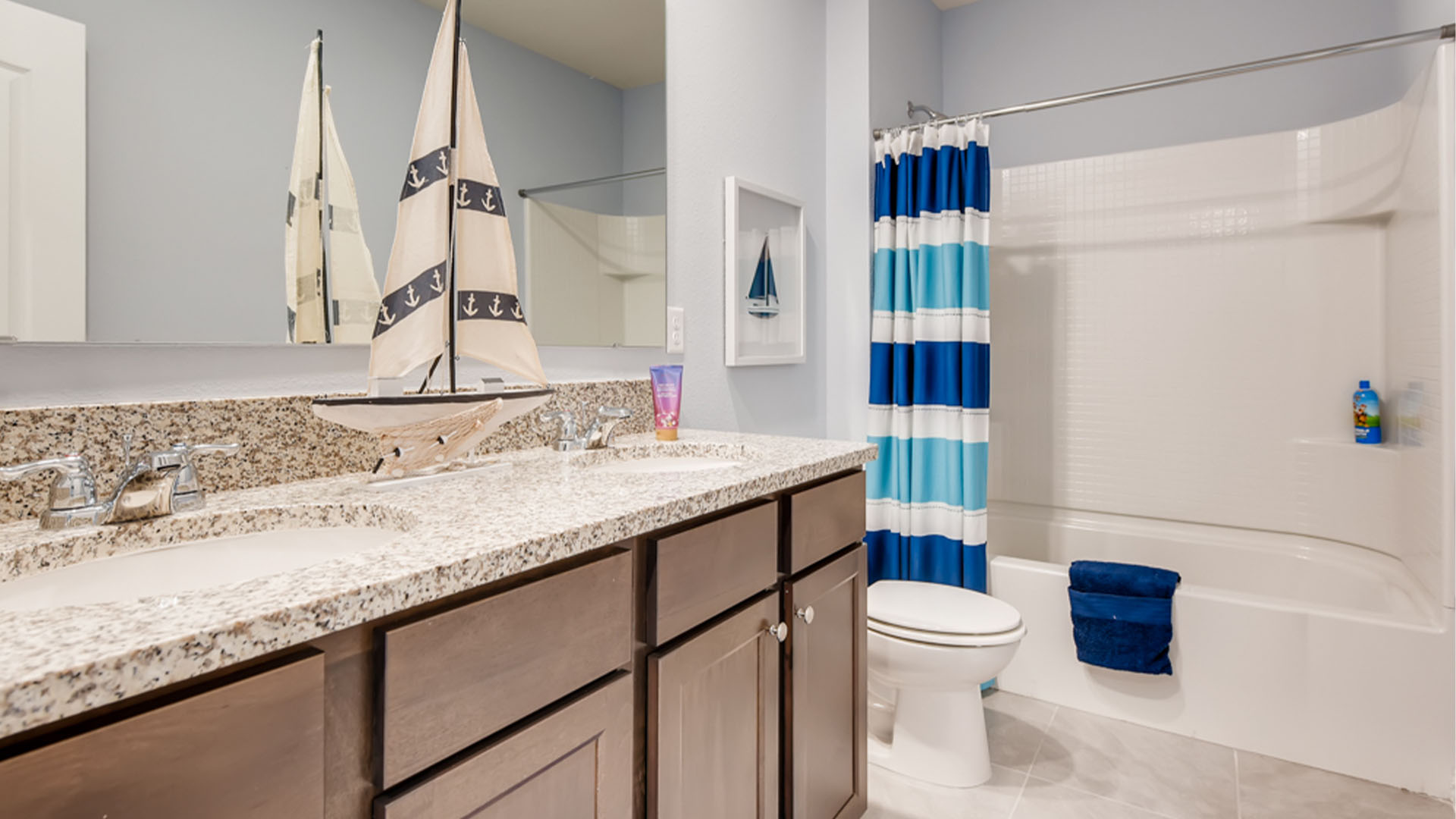 Kitchen with island seating, granite counters, spacious pantry and stainless-steel appliances.