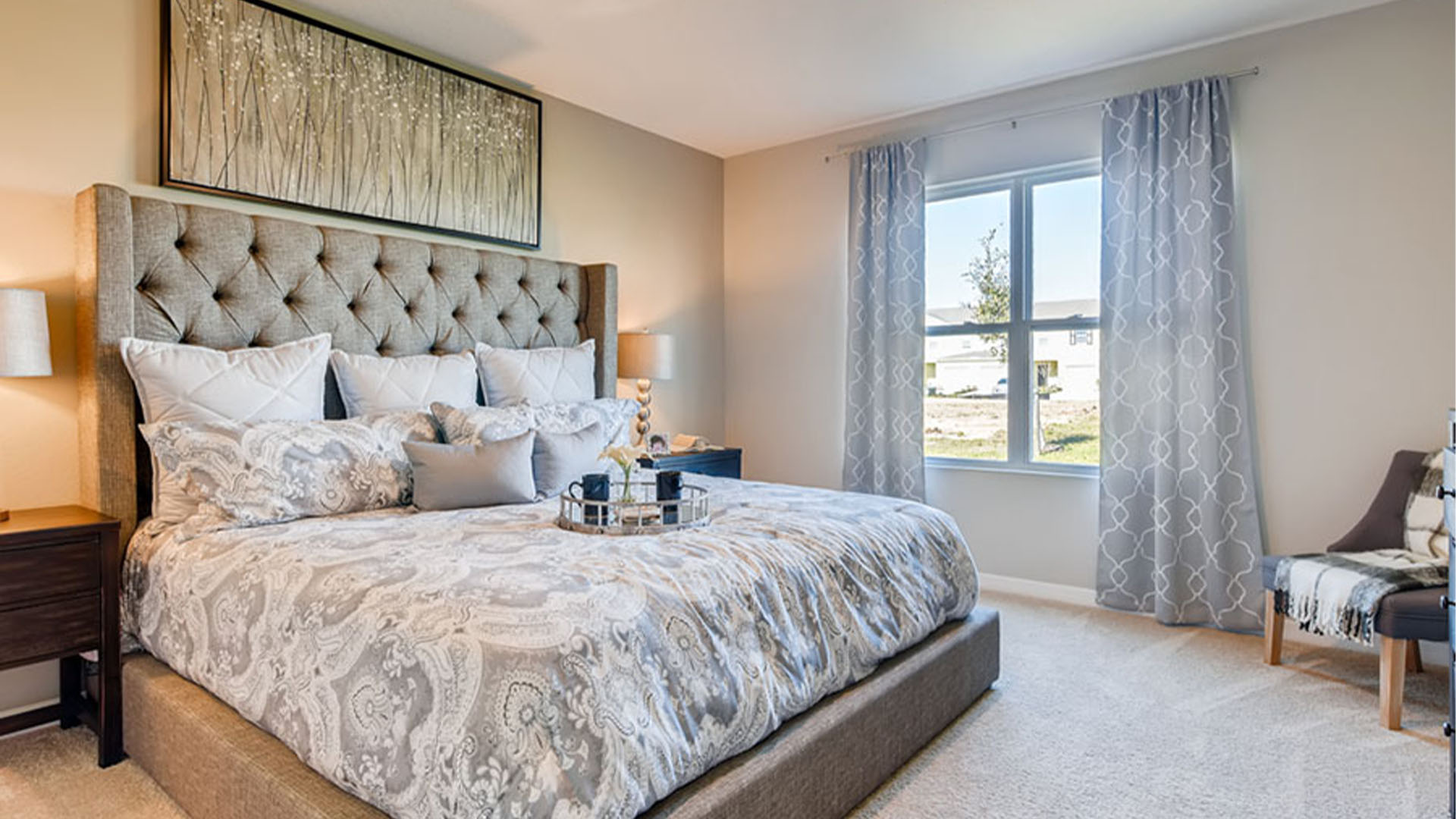 Spacious primary bedroom with king size bed, carpet flooring, natural lighting and a walk in closet.