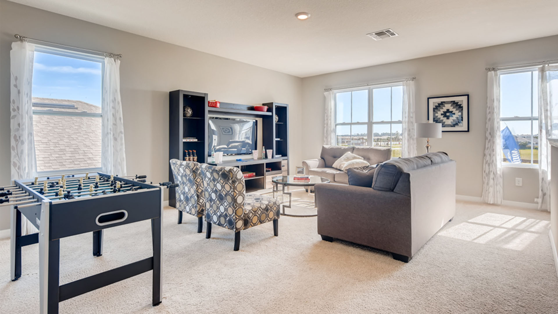 Open concept living area with couch seating and access to the backyard thru slider door.