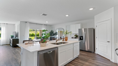 Kitchen with island seating, granite counters, spacious pantry and stainless-steel appliances.
