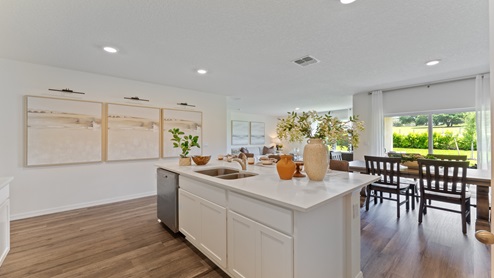 Kitchen with island seating, granite counters, spacious pantry and stainless-steel appliances.