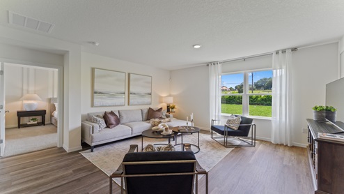 Open concept living area with couch seating and access to the backyard thru slider door.