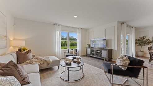 Open concept living area with couch seating and access to the backyard thru slider door.
