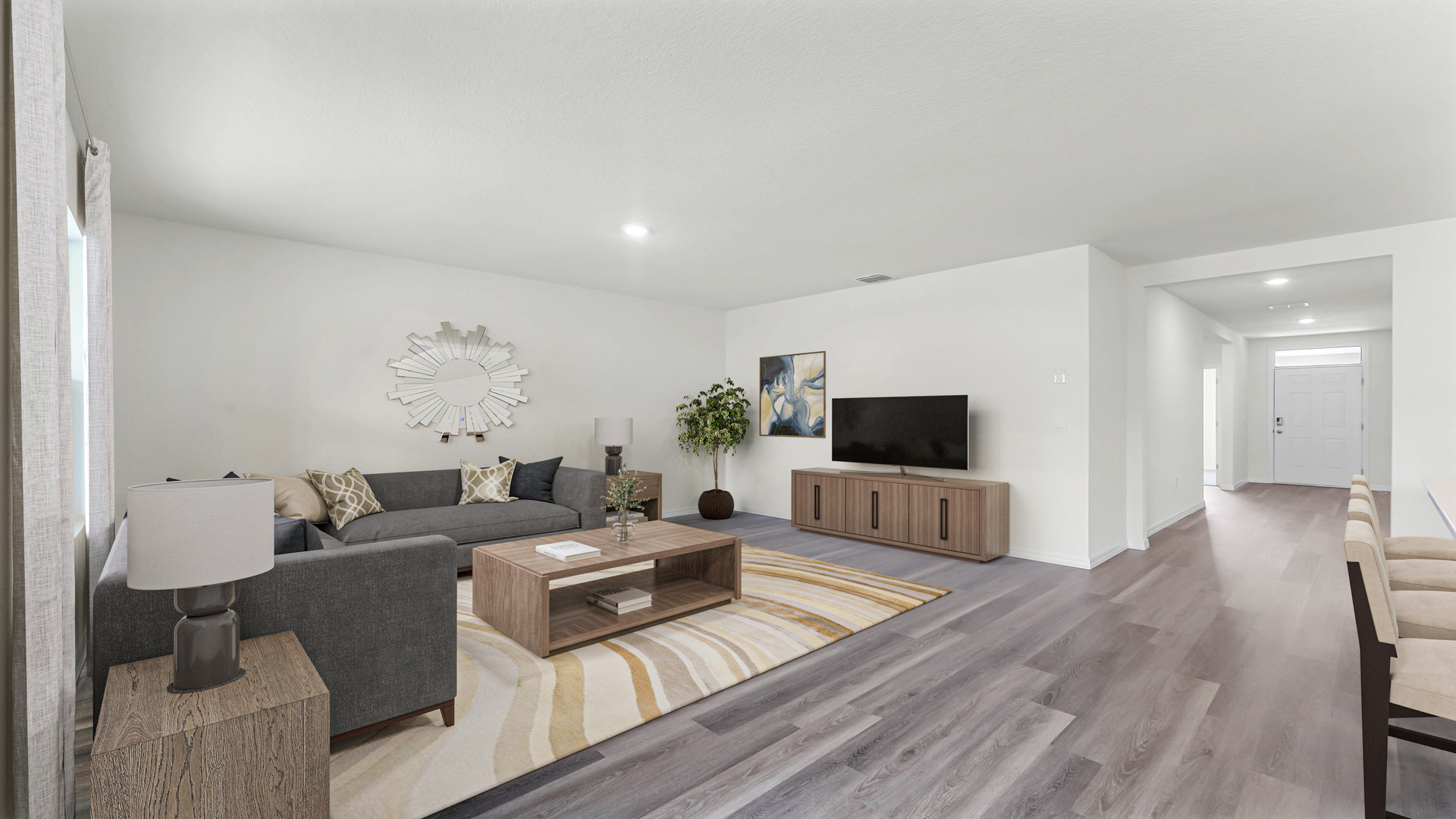 Living area with couch seating, natural lighting, luxury vinyl plank flooring overseeing entry way.