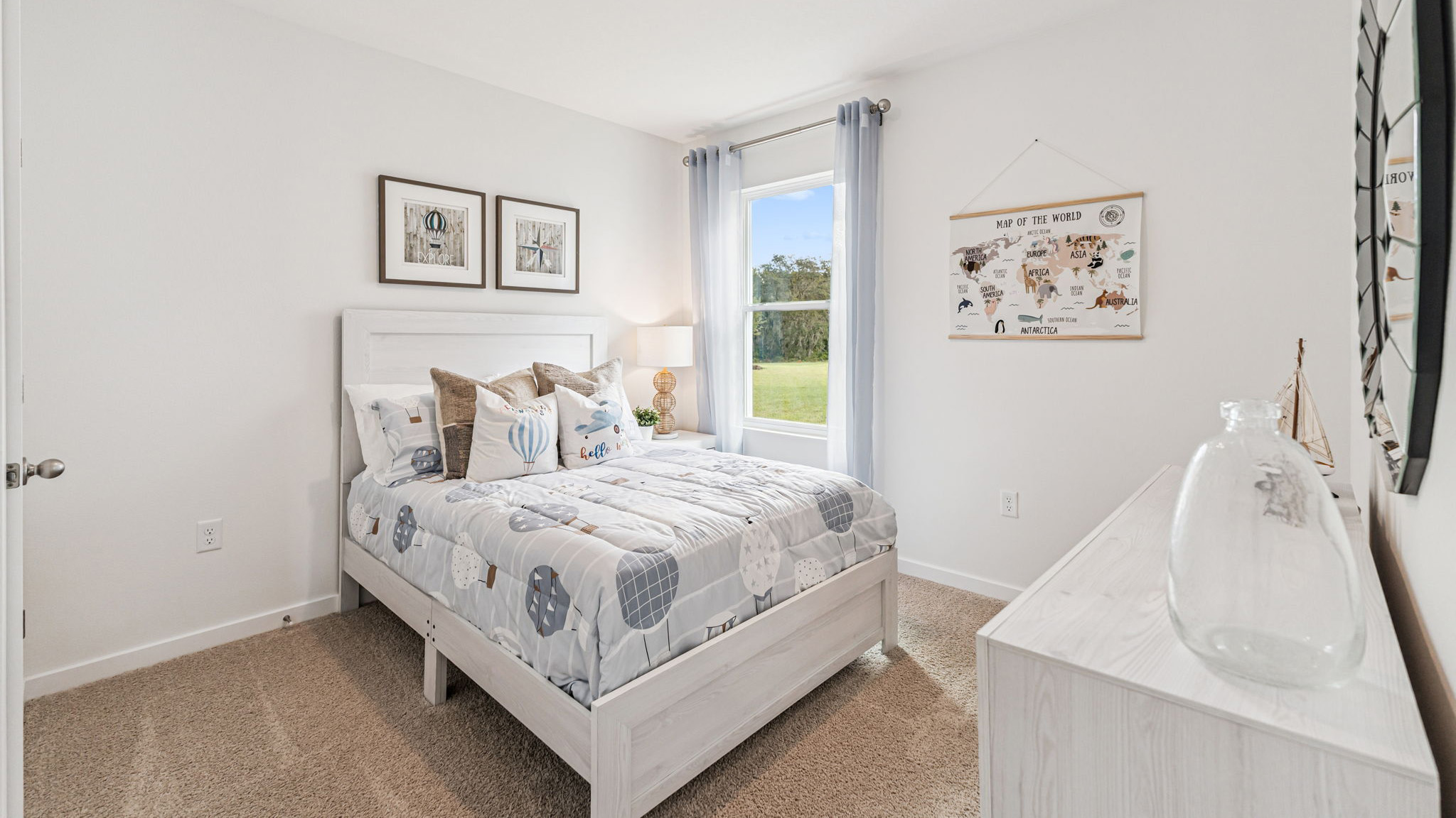 Spacious primary bedroom with king size bed, carpet flooring, natural lighting.
