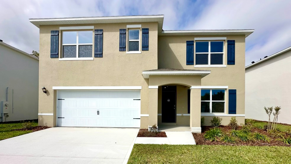 two story new home with large windows and 2 car garage.