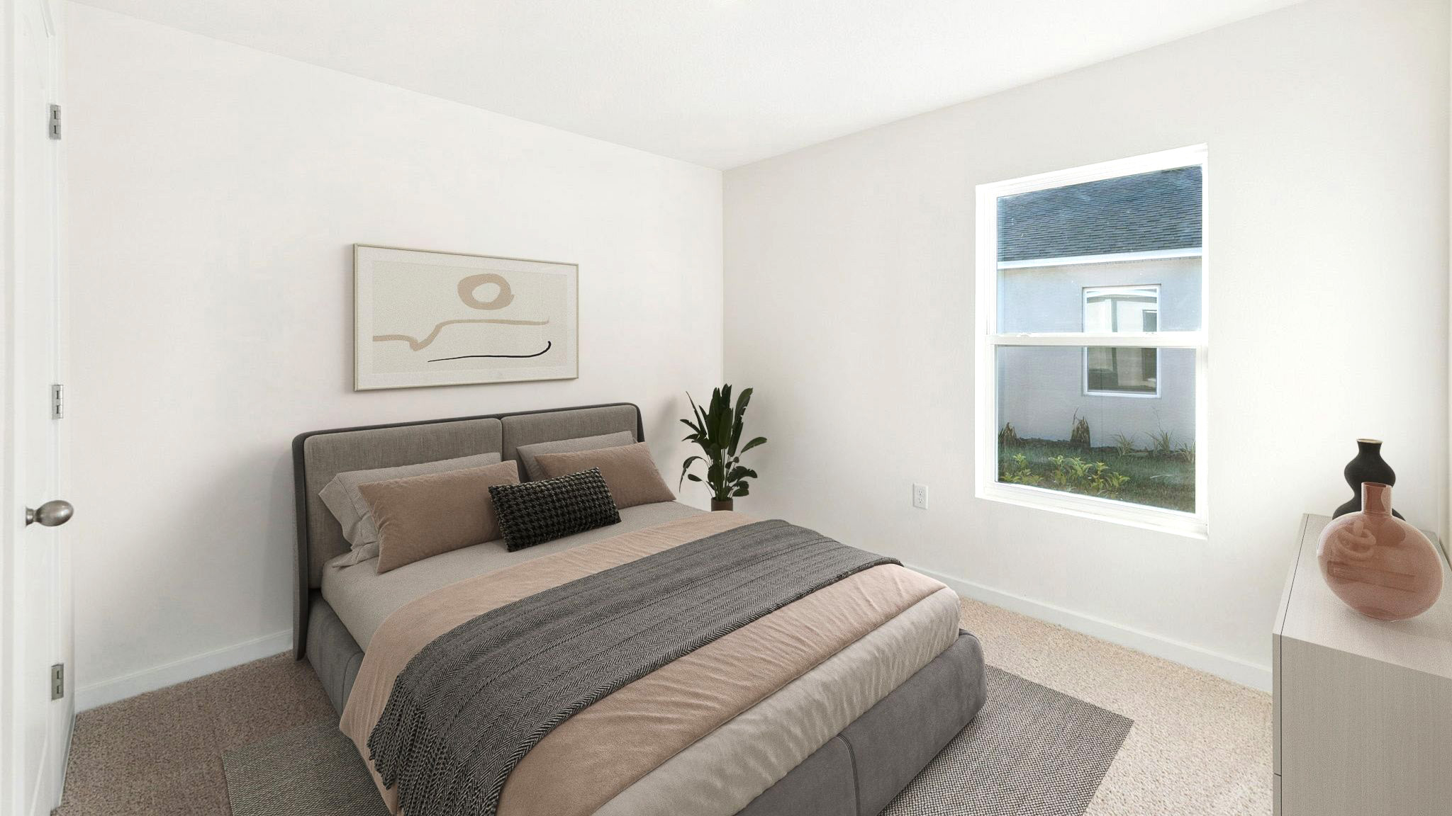 Spacious primary bedroom with king size bed, carpet flooring, natural lighting.