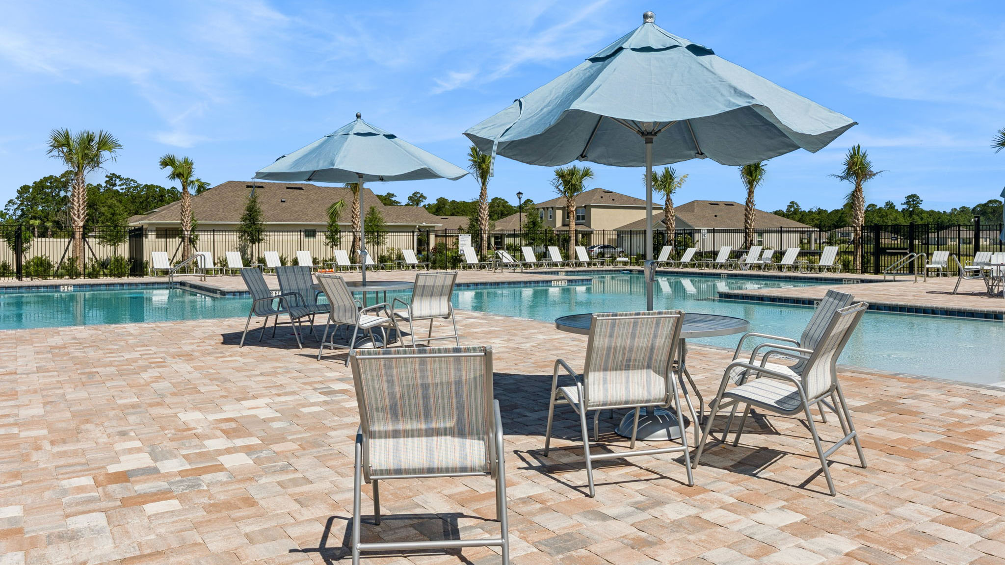 Table with umbrella and chairs by pool