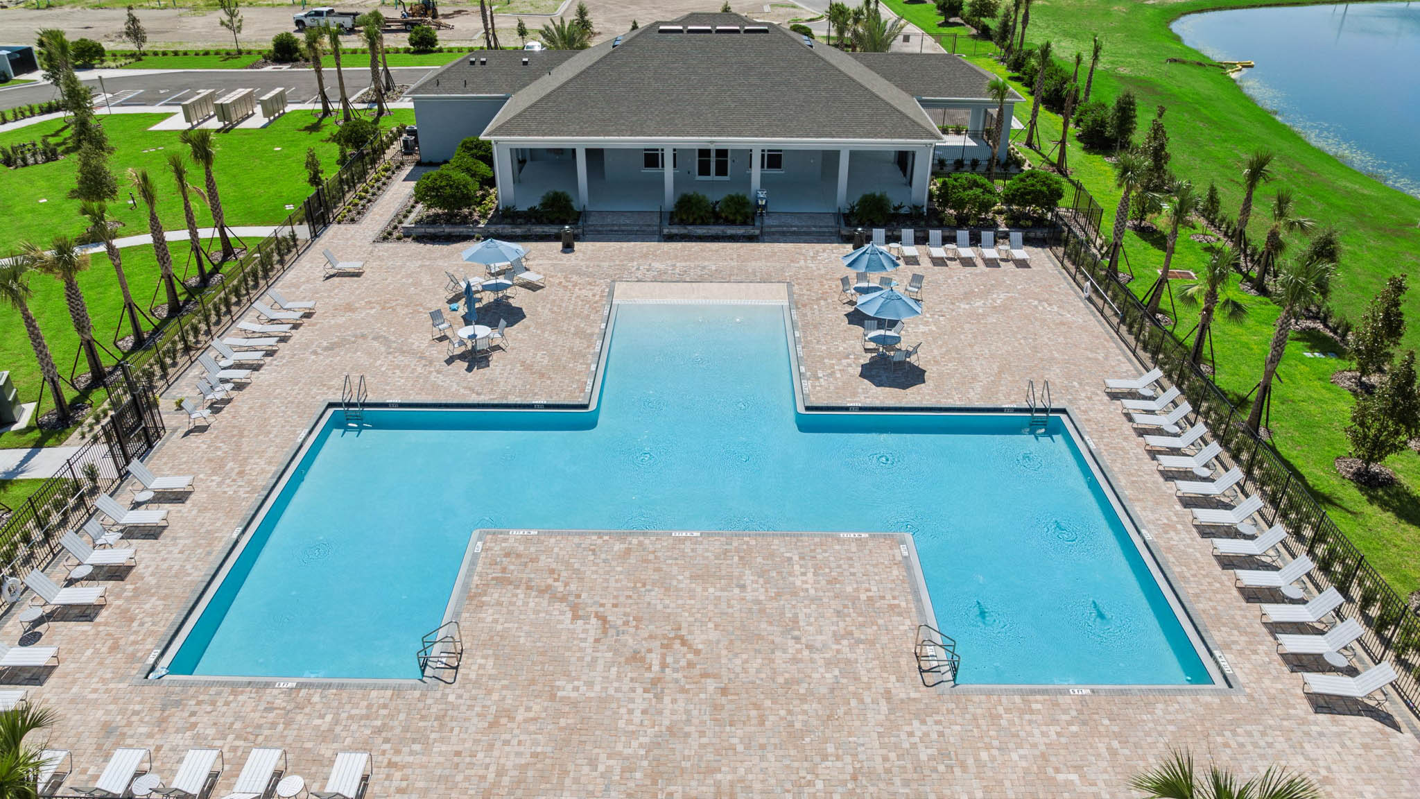 Drone shot of pool wiht lounge chairs and unbrellas