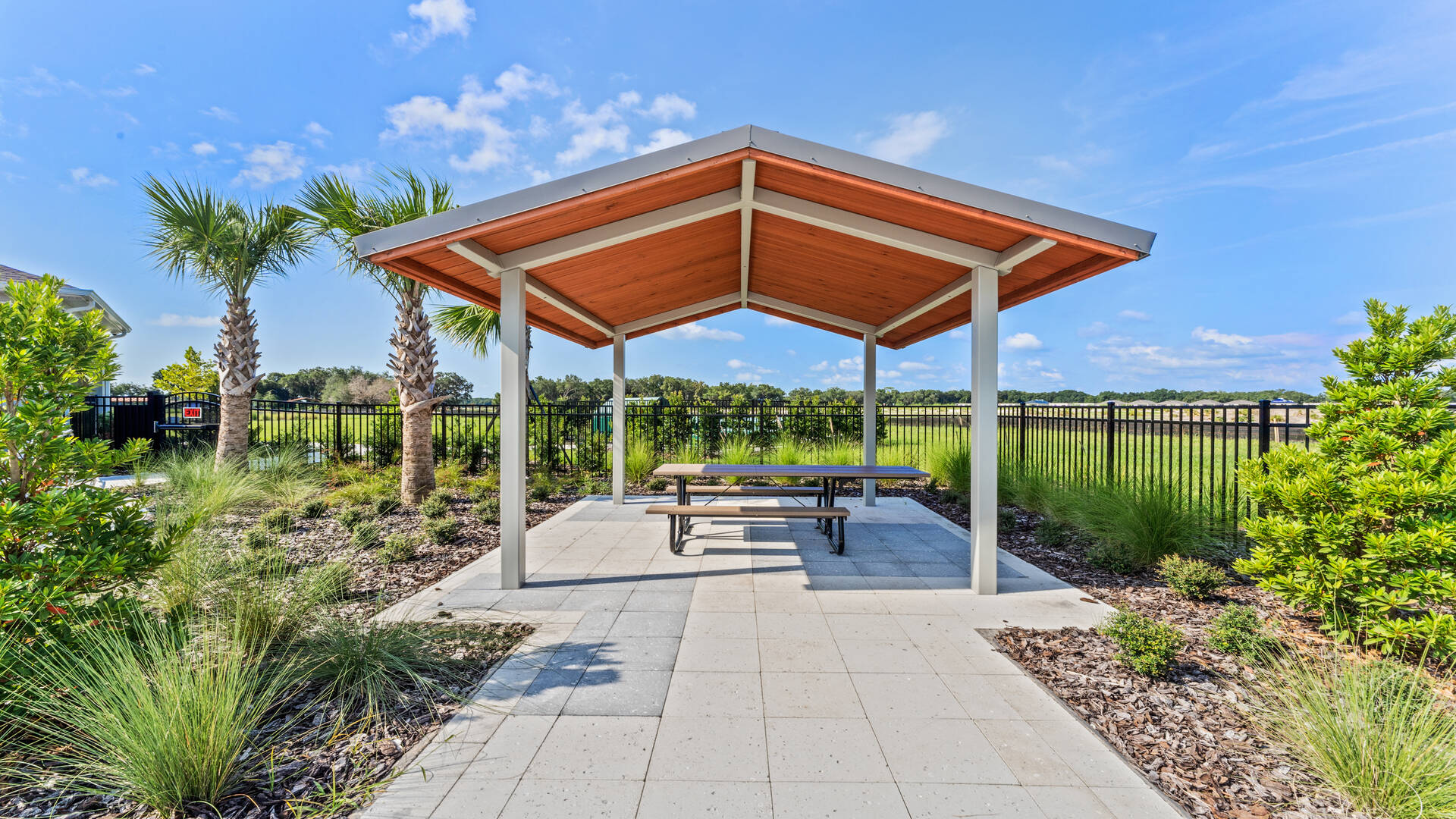A pleasant, roofed area with tables for outdoor dining.