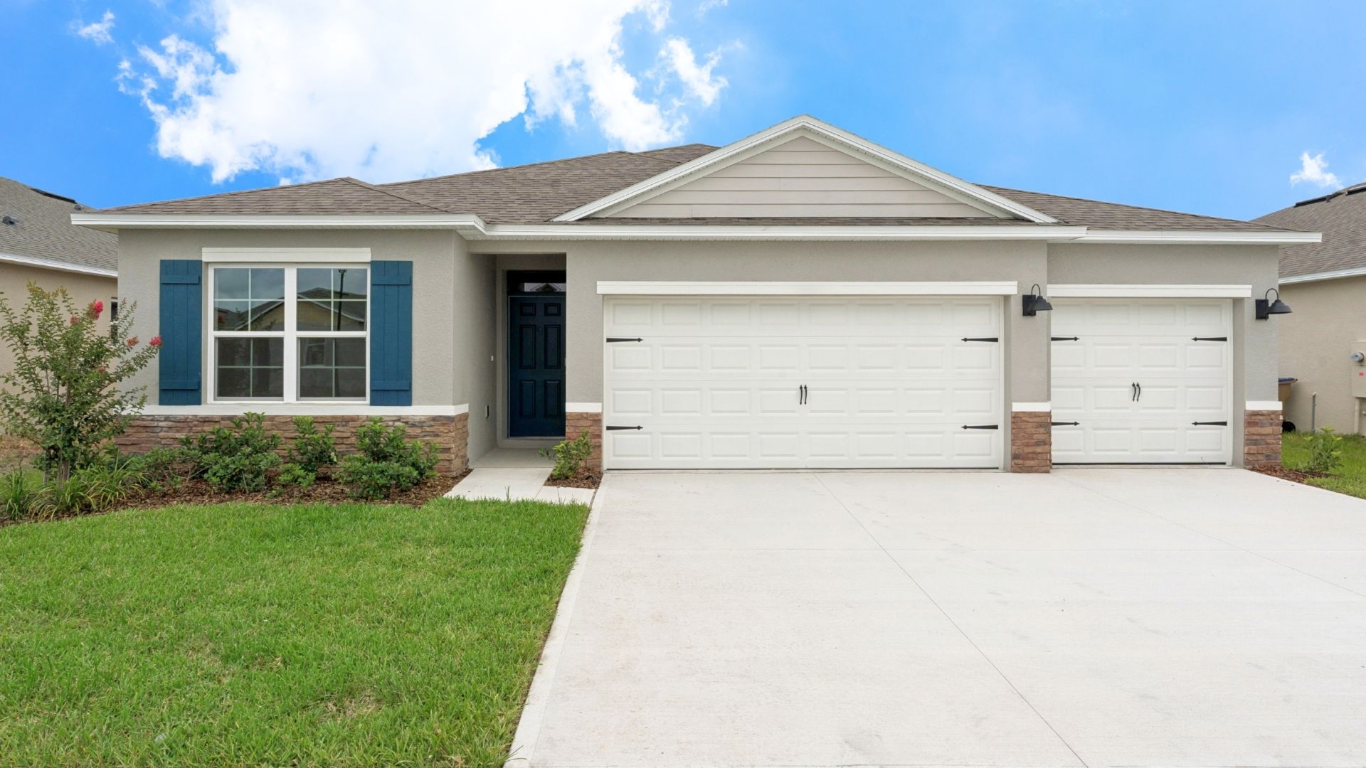 Single story new home with large windows and 2 car garage.