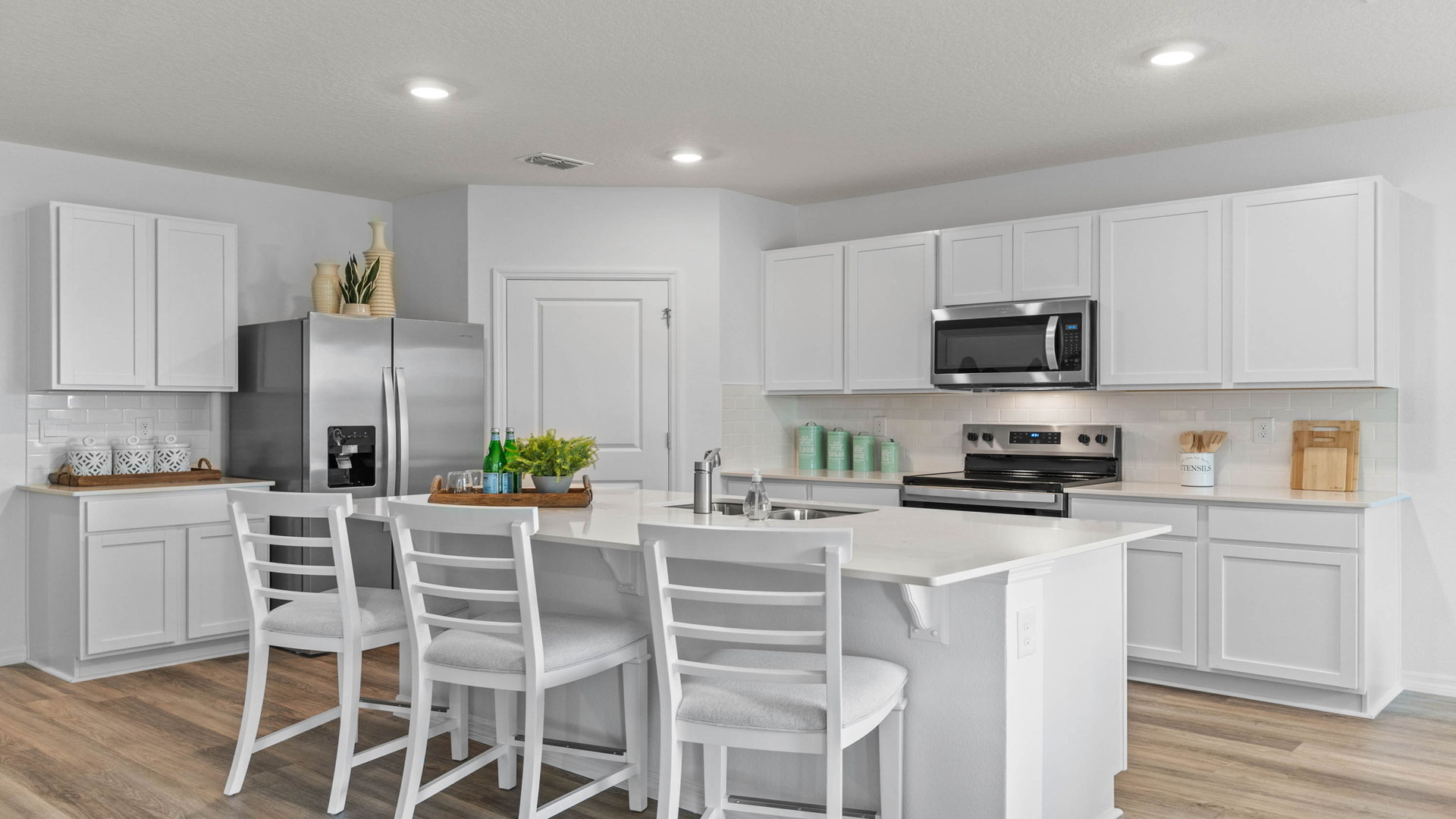 Kitchen with island seating, quartz counters, spacious pantry and stainless steel appliances