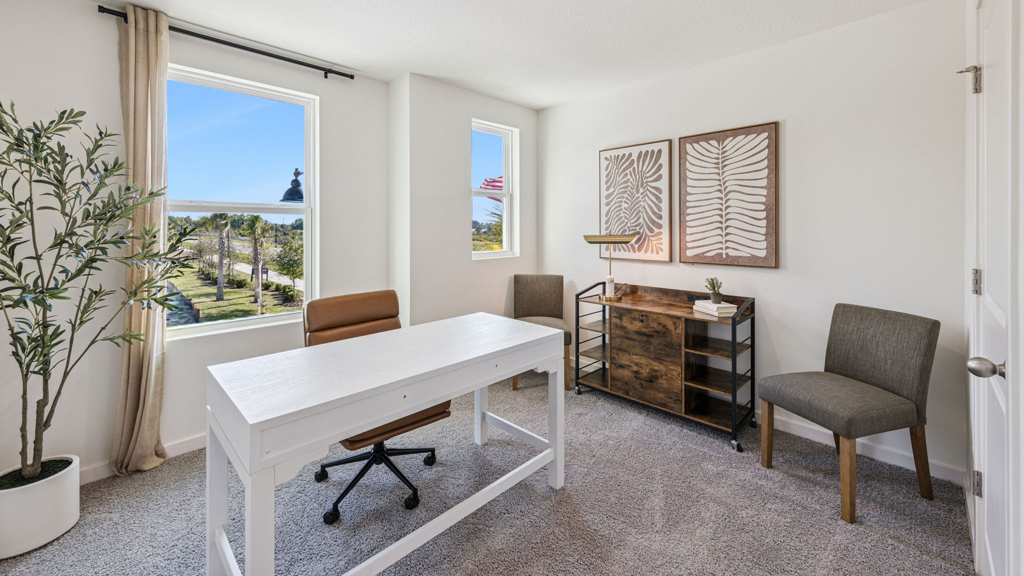 Spacious primary bedroom with king size bed, carpet flooring, natural lighting.