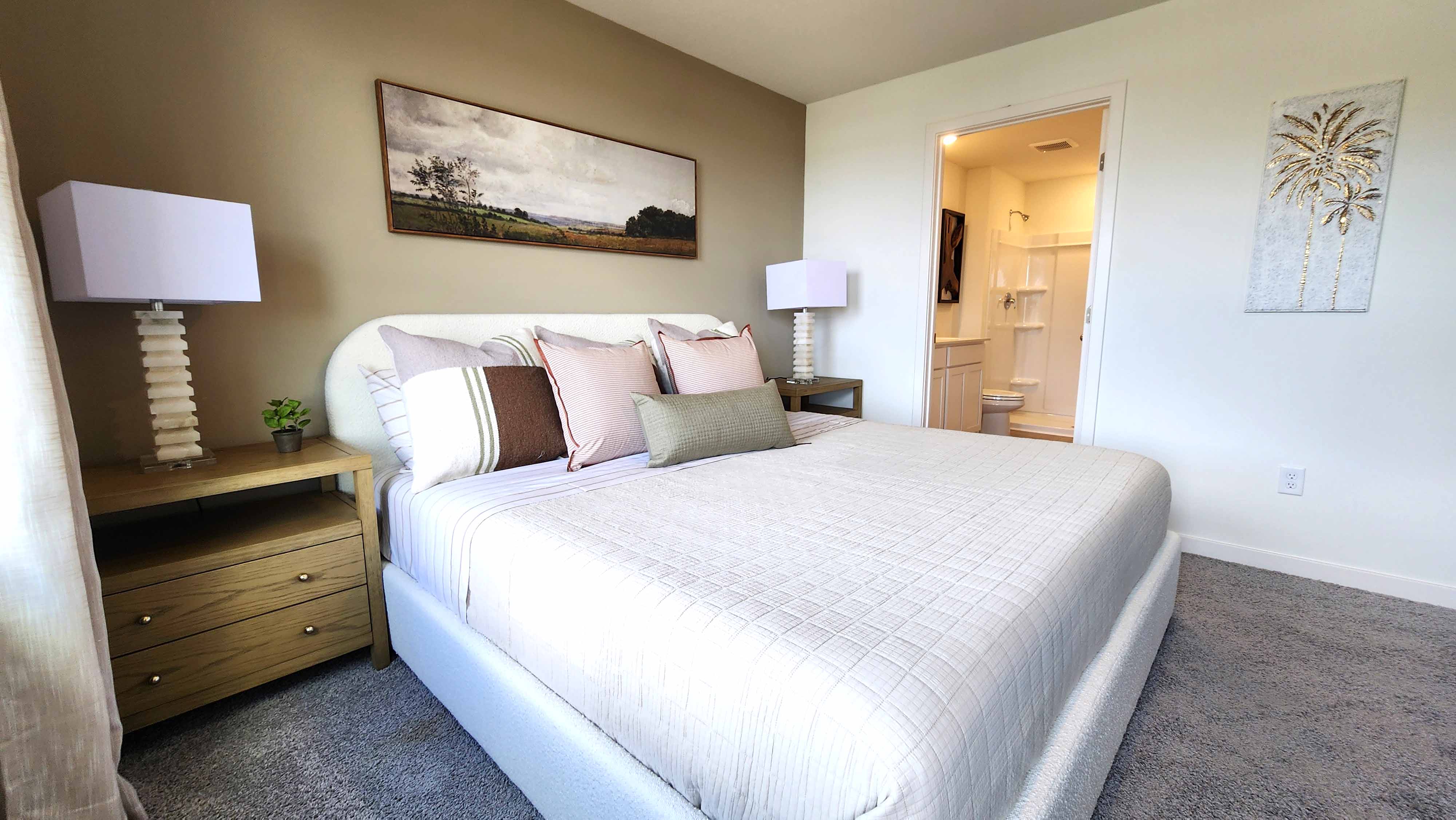 Guest bedroom with bed, nighstands and natural lighting.
