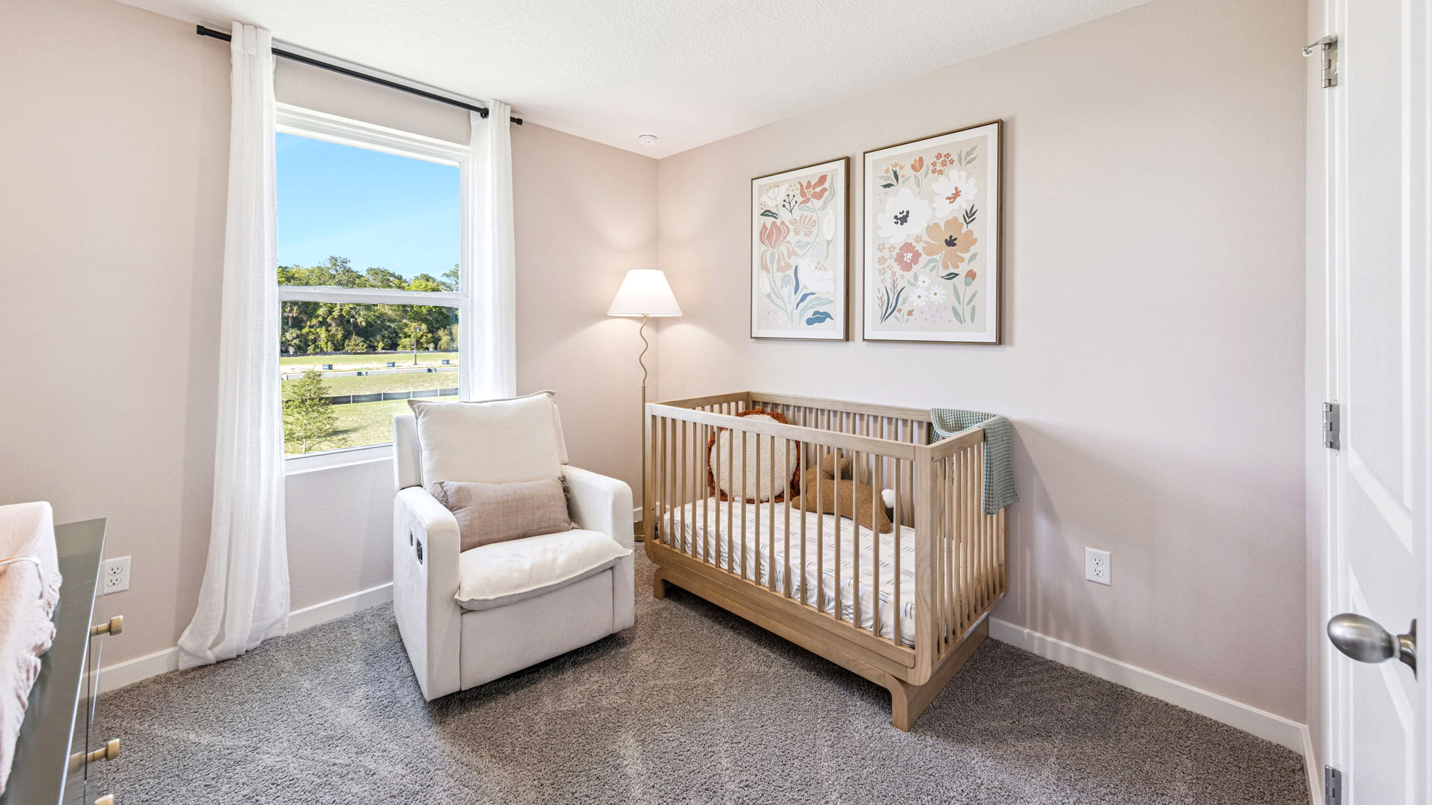 Spacious primary bedroom with king size bed, carpet flooring, natural lighting.