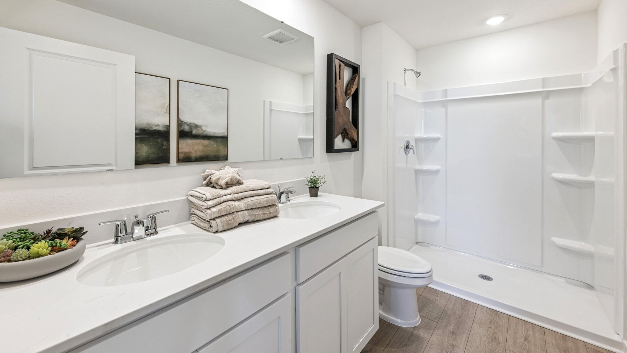 Modern bathroom with double vanity, large wall mirror, cabinets and quartz countertops
