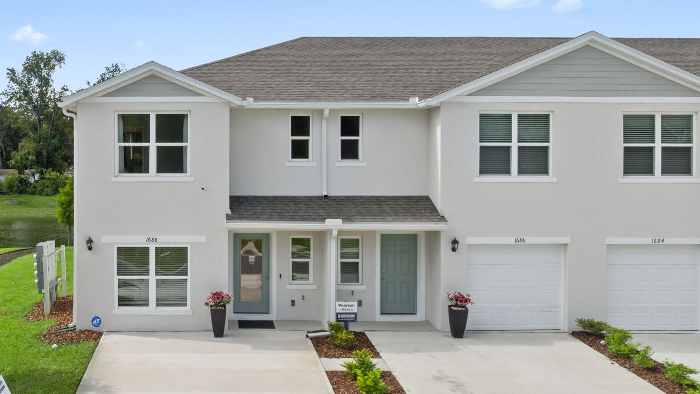 attached townhome with large windows and 2 car garage.