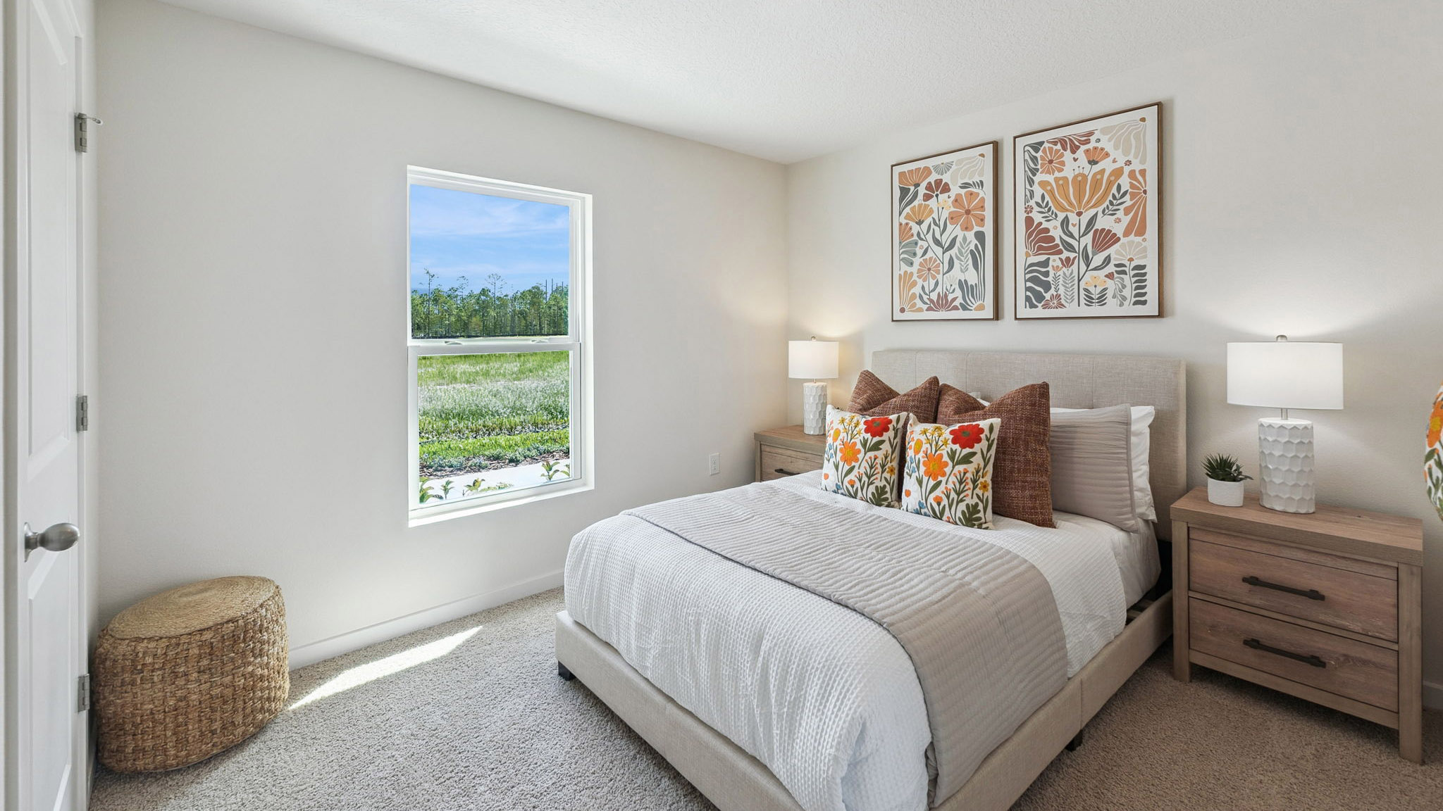 Spacious primary bedroom with king size bed, carpet flooring, natural lighting.
