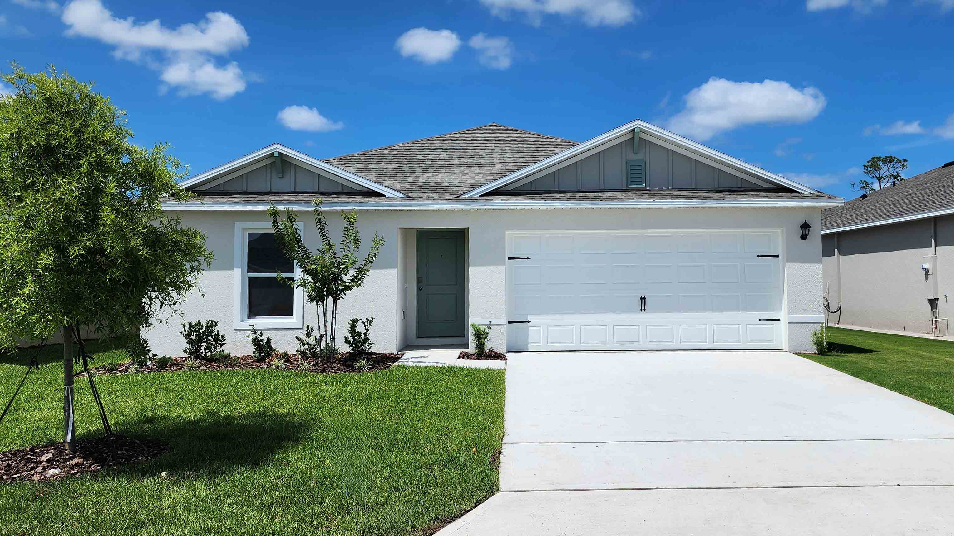 Single story new home with large windows and 2 car garage.