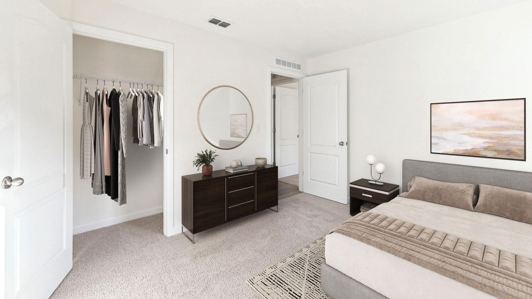 Spacious primary bedroom with king size bed, carpet flooring, natural lighting.