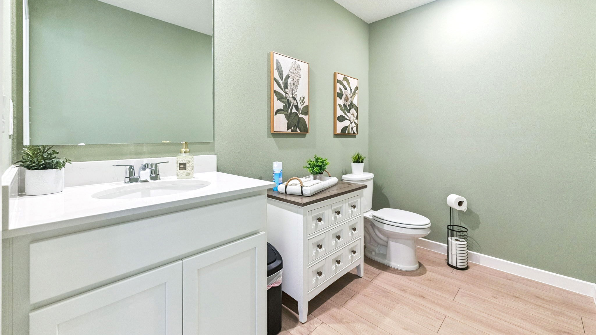 Guest bathroom with single vanity quartz countertops, toilet and shower.