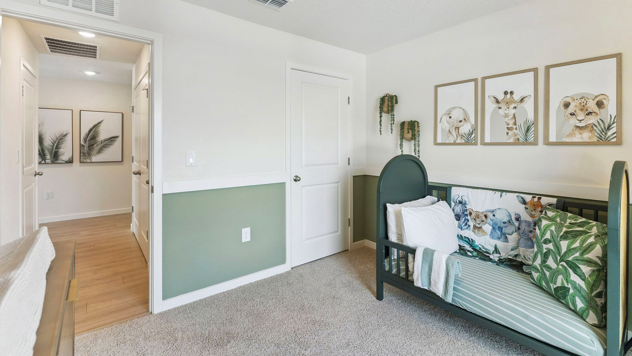 Spacious primary bedroom with king size bed, carpet flooring, natural lighting.