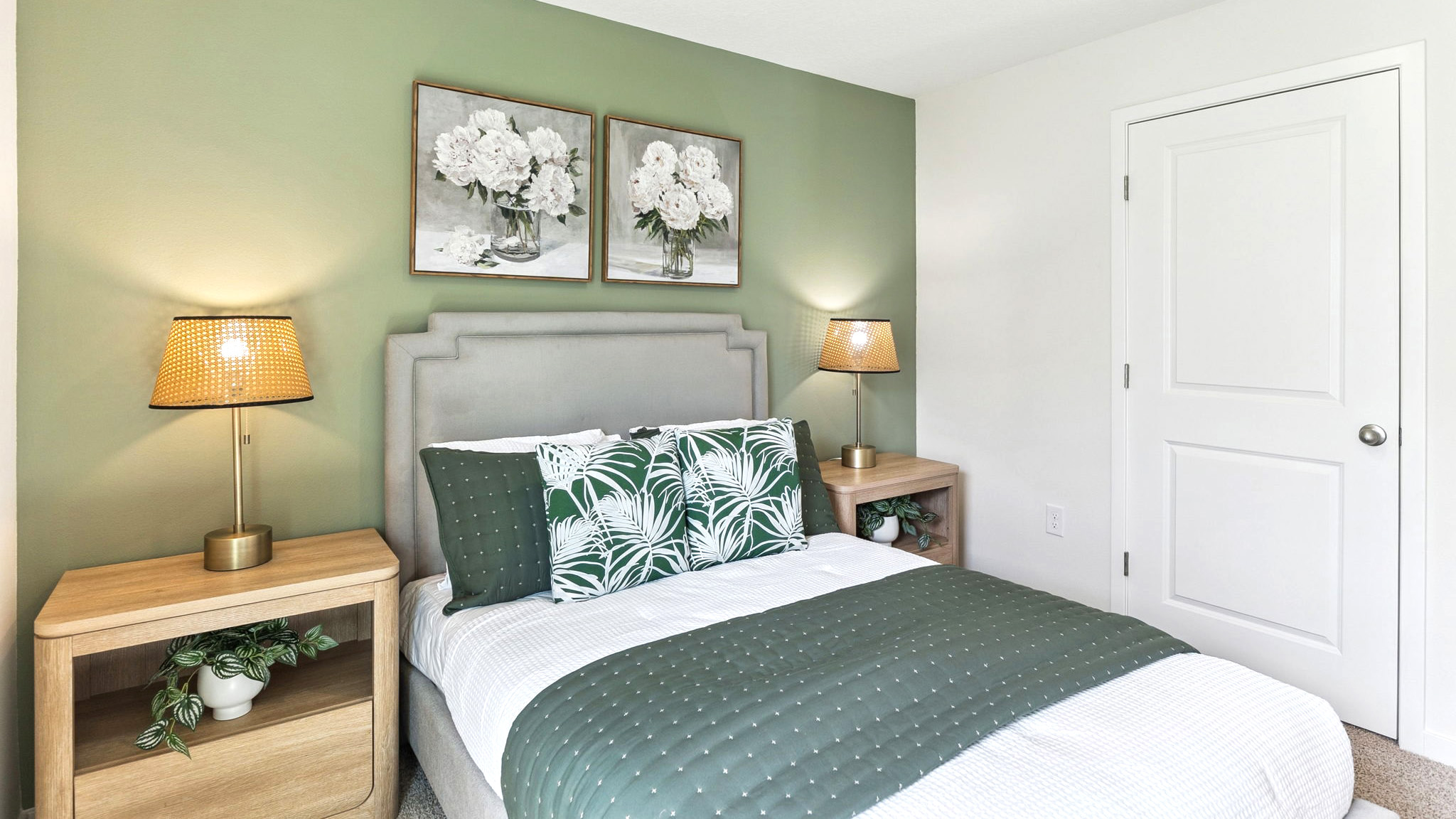 Spacious primary bedroom with king size bed, carpet flooring, natural lighting.