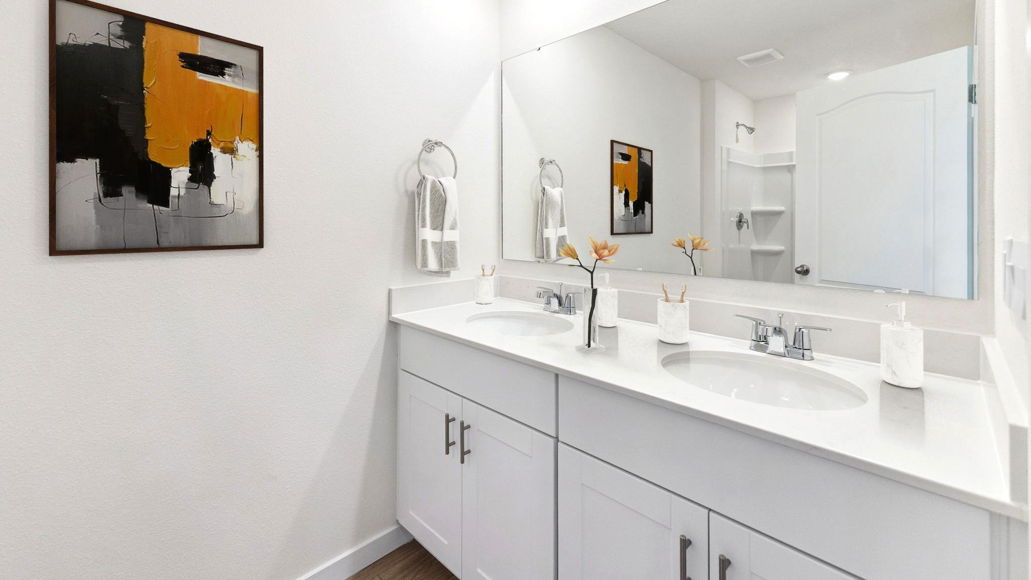 Modern bathroom with double vanity, large wall mirror, cabinets and quartz countertops