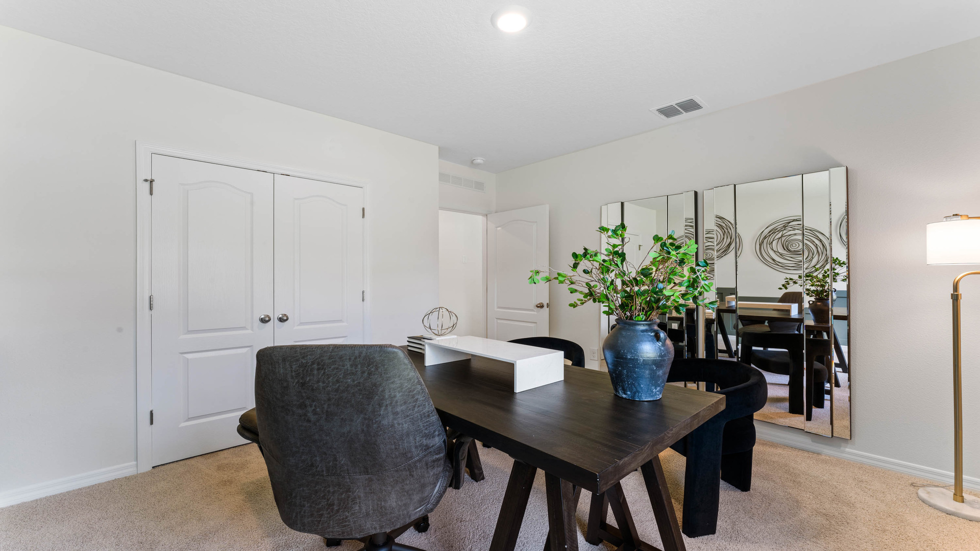 Living area with couch seating, entertainment system overseeing access to guest bathroom.