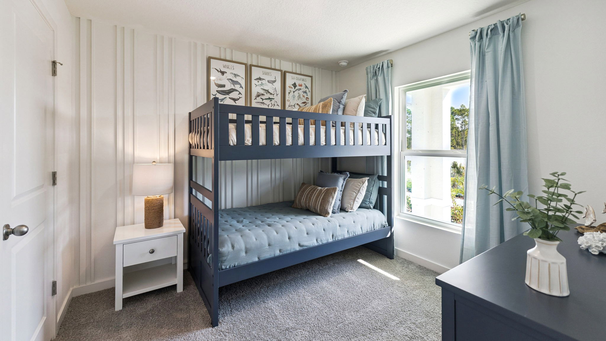 Spacious primary bedroom with king size bed, carpet flooring, natural lighting.