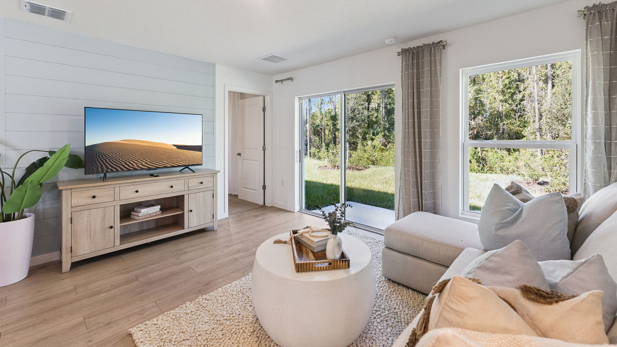 Living area with couch seating, entertainment system and natural lighting