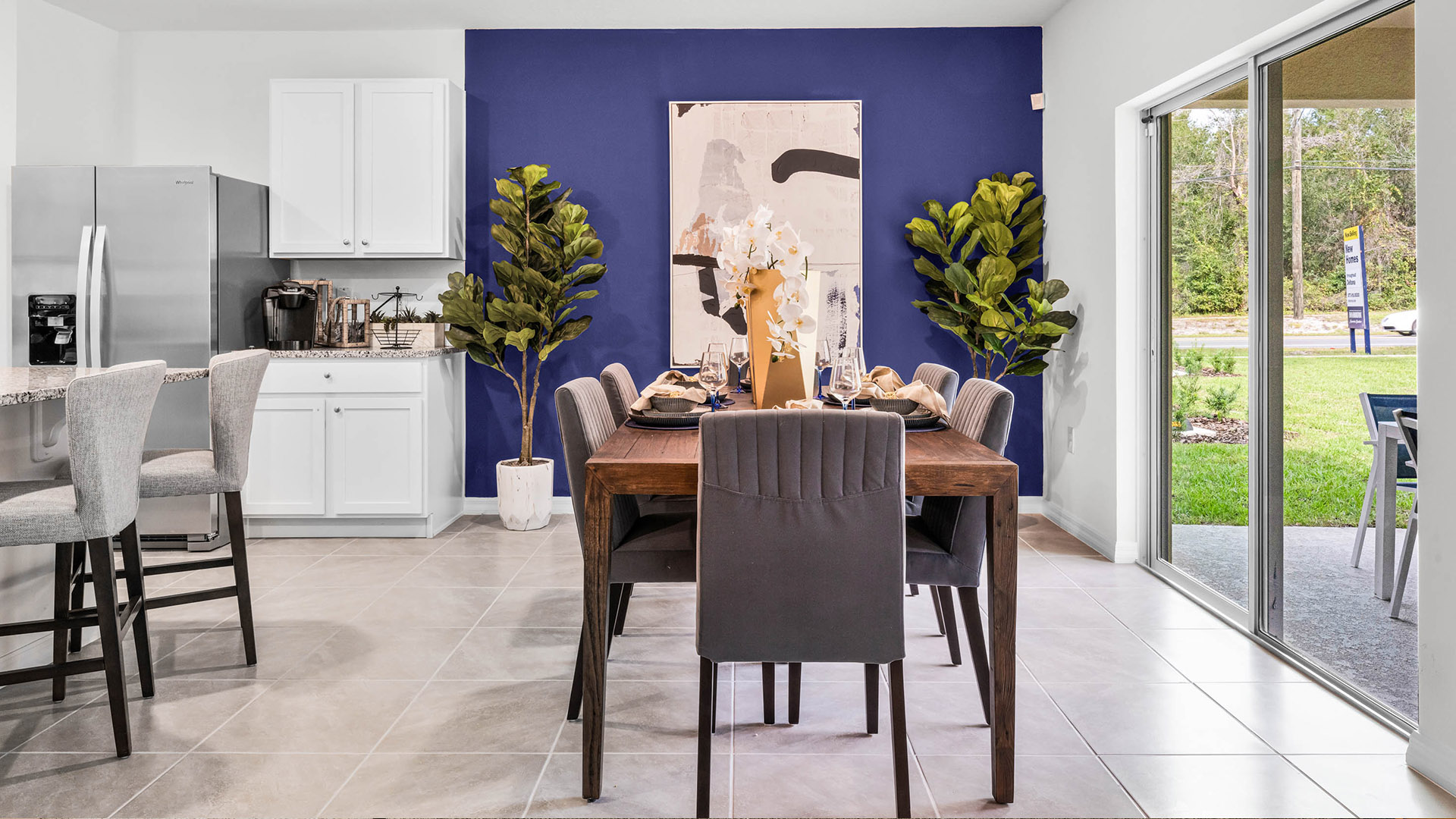 Dining room adjacent to the kitchen with table, chairs and tile flooring.