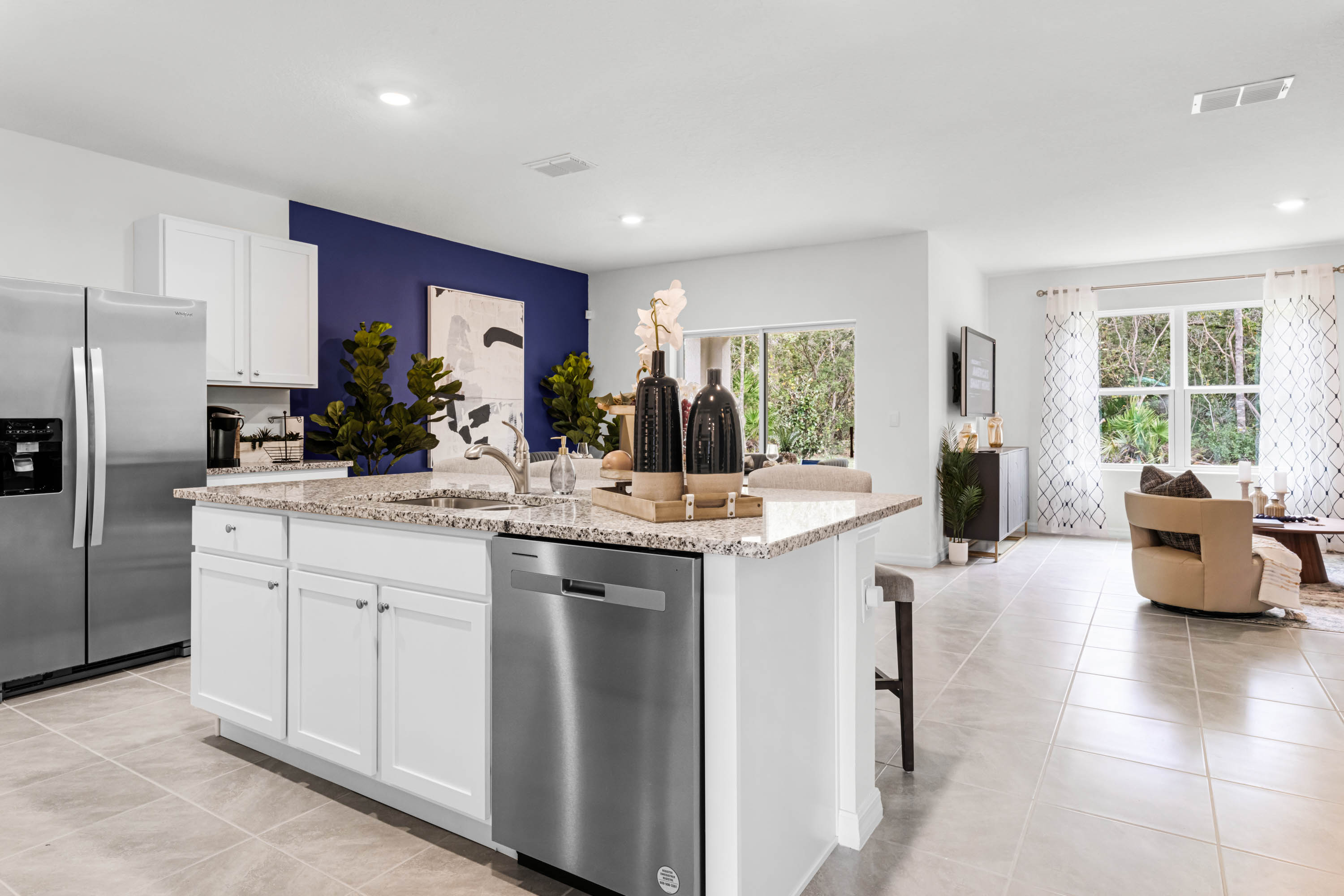Kitchen with island seating, granite counters, spacious pantry and stainless-steel appliances.