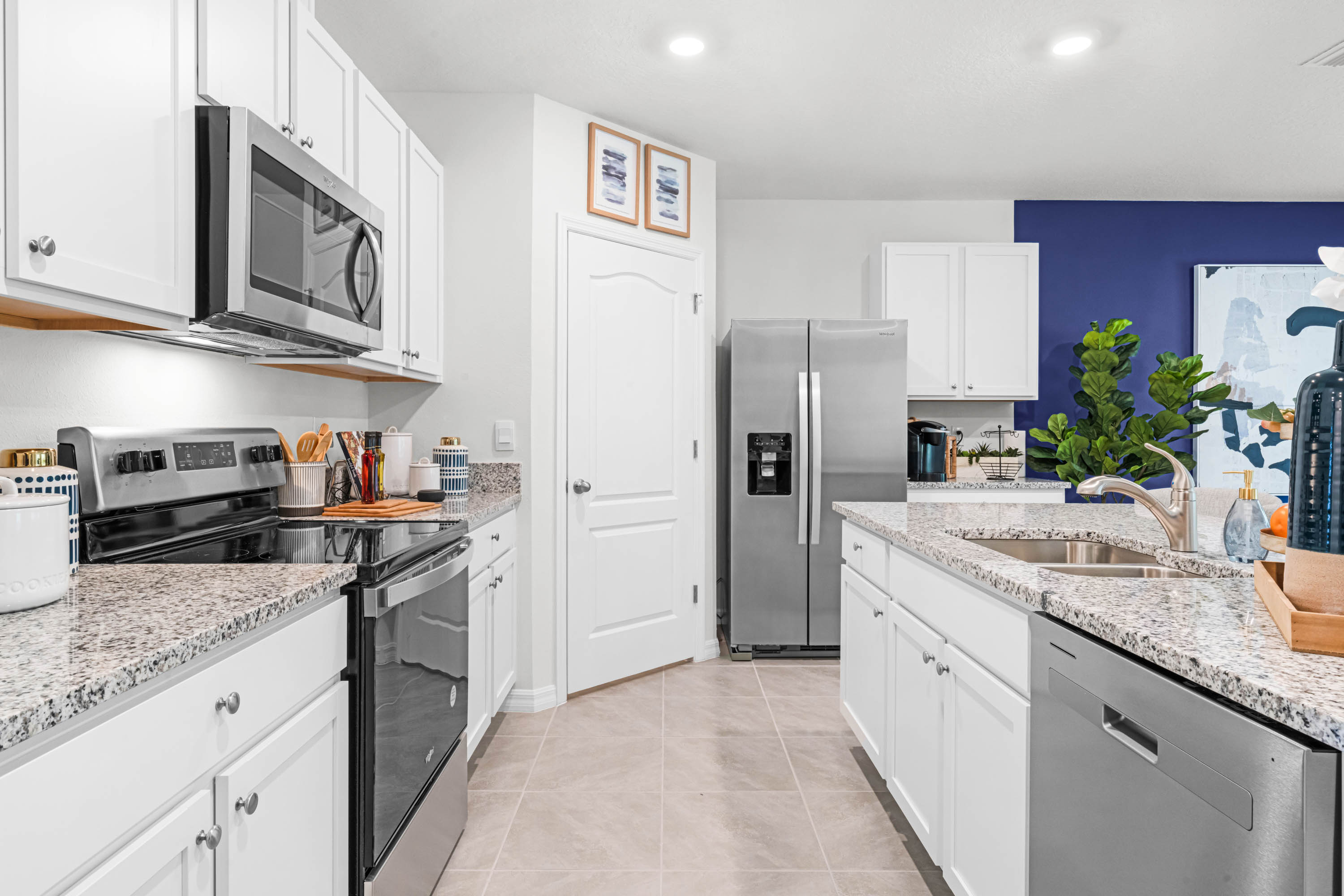 Kitchen with island seating, granite counters, spacious pantry and stainless-steel appliances.